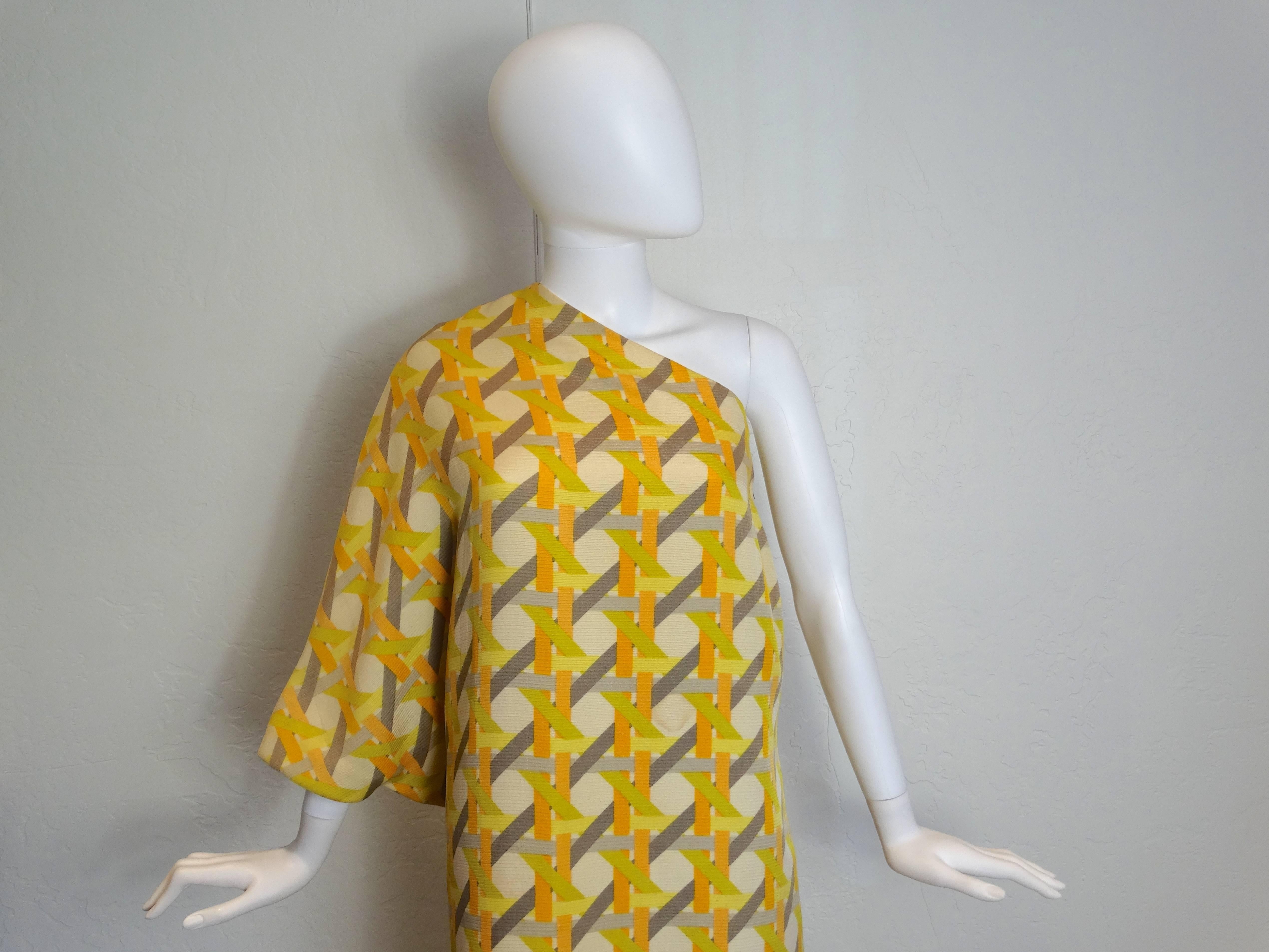 A beautiful 1960's caftan one shoulder dress created in Italy. In a great color combo with golds, grays and cream, a true 60's lattice print.  One shoulder dolman cut sleeve. Lined in silk.  

Measurements:

55.5 inches Long
44 inch waist and