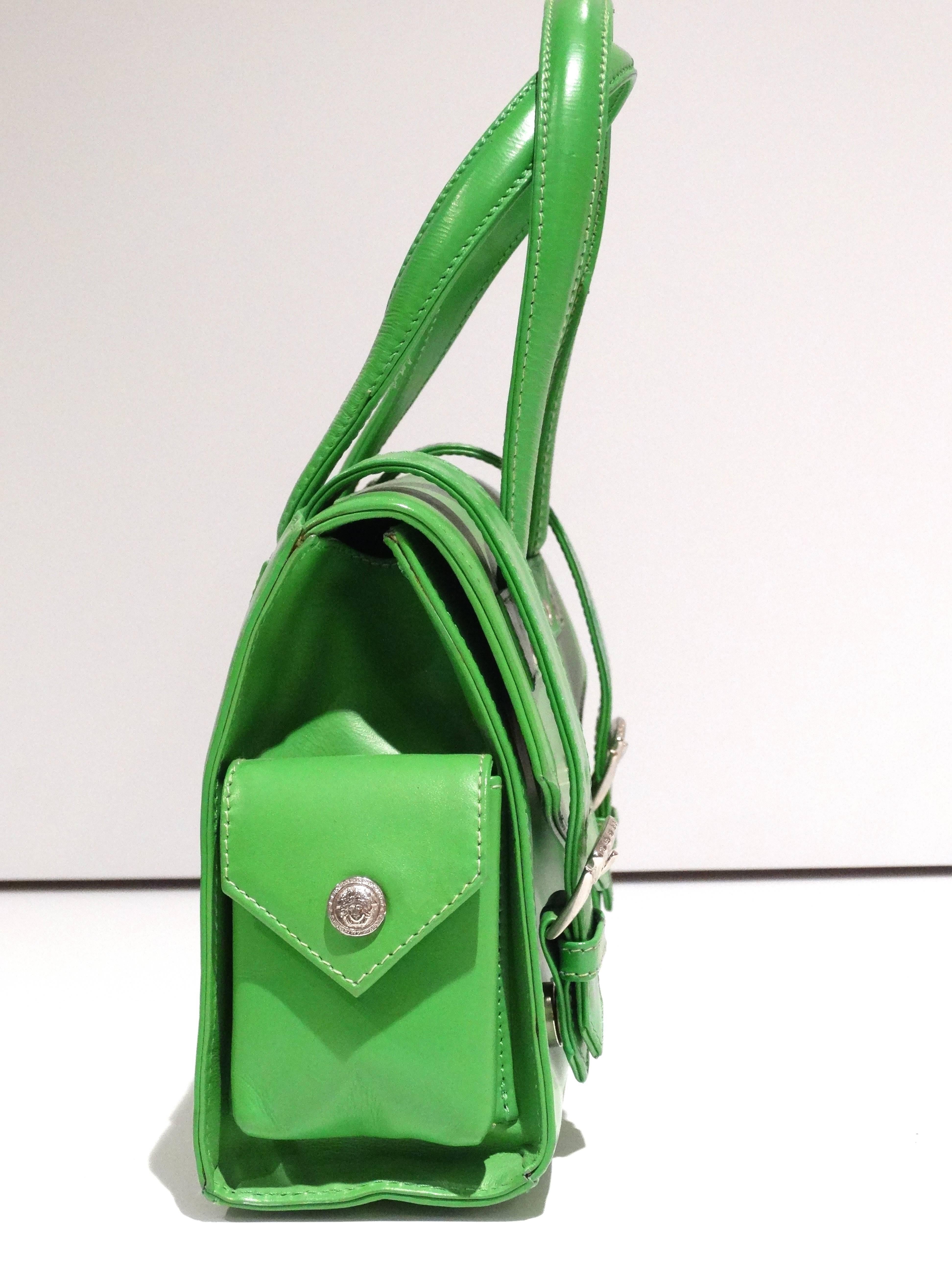 A great handbag designed by Gianni Versace in the early 1990's. In a fabulous kelly green leather with silver hardware. Classic Medusa hardware in the center of the bag and on the sides. Buckle envelope magnetic flap closure opens to the inside of