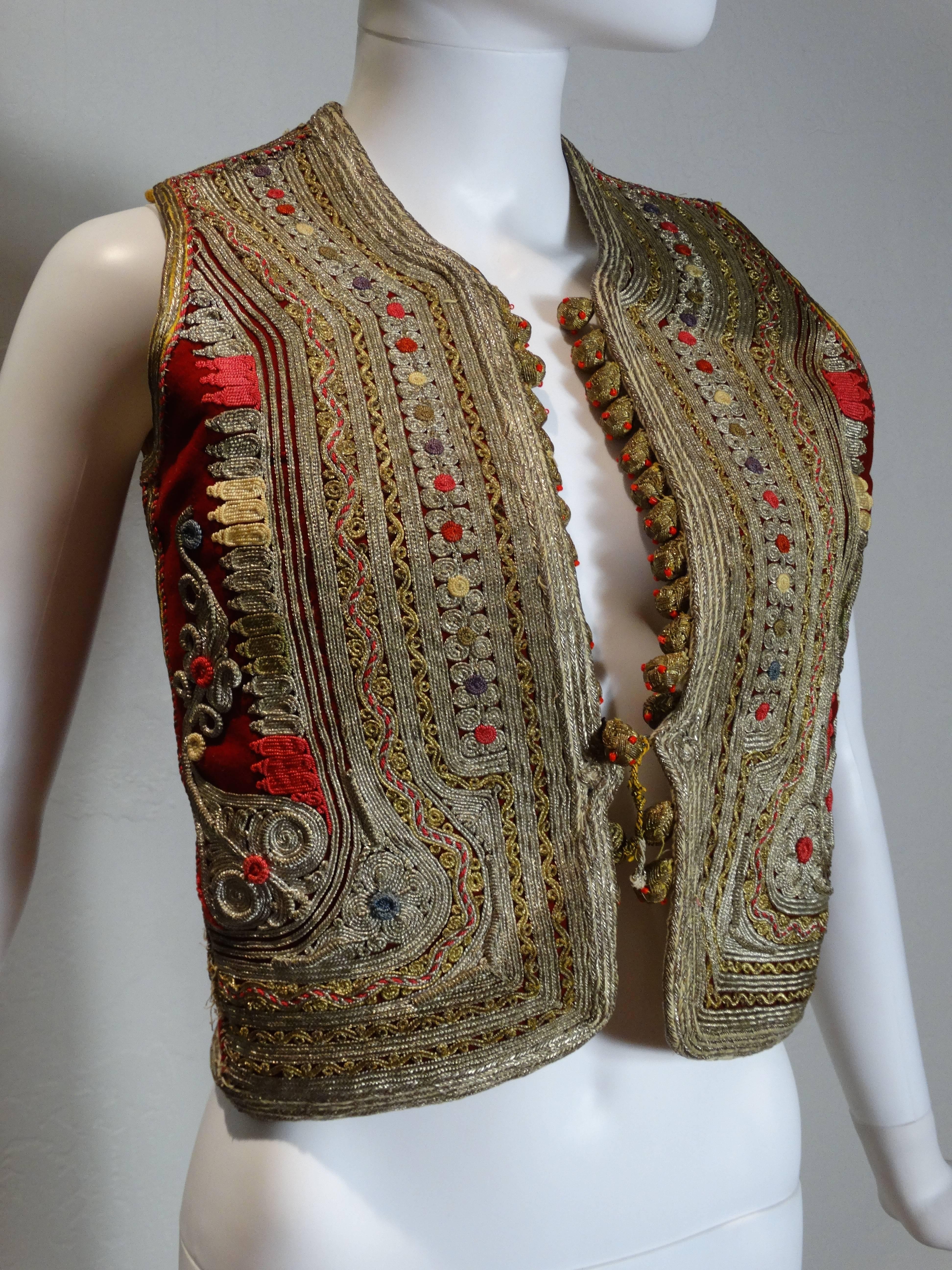 Stunning and ultra rare Authentic late 19th century Antique Ottoman Turkish Islamic art Vest in blood red wool felt decorated with elaborate couched gold thread and tassels, trimmed with gold thread buttons with coral beads. Floral print richly