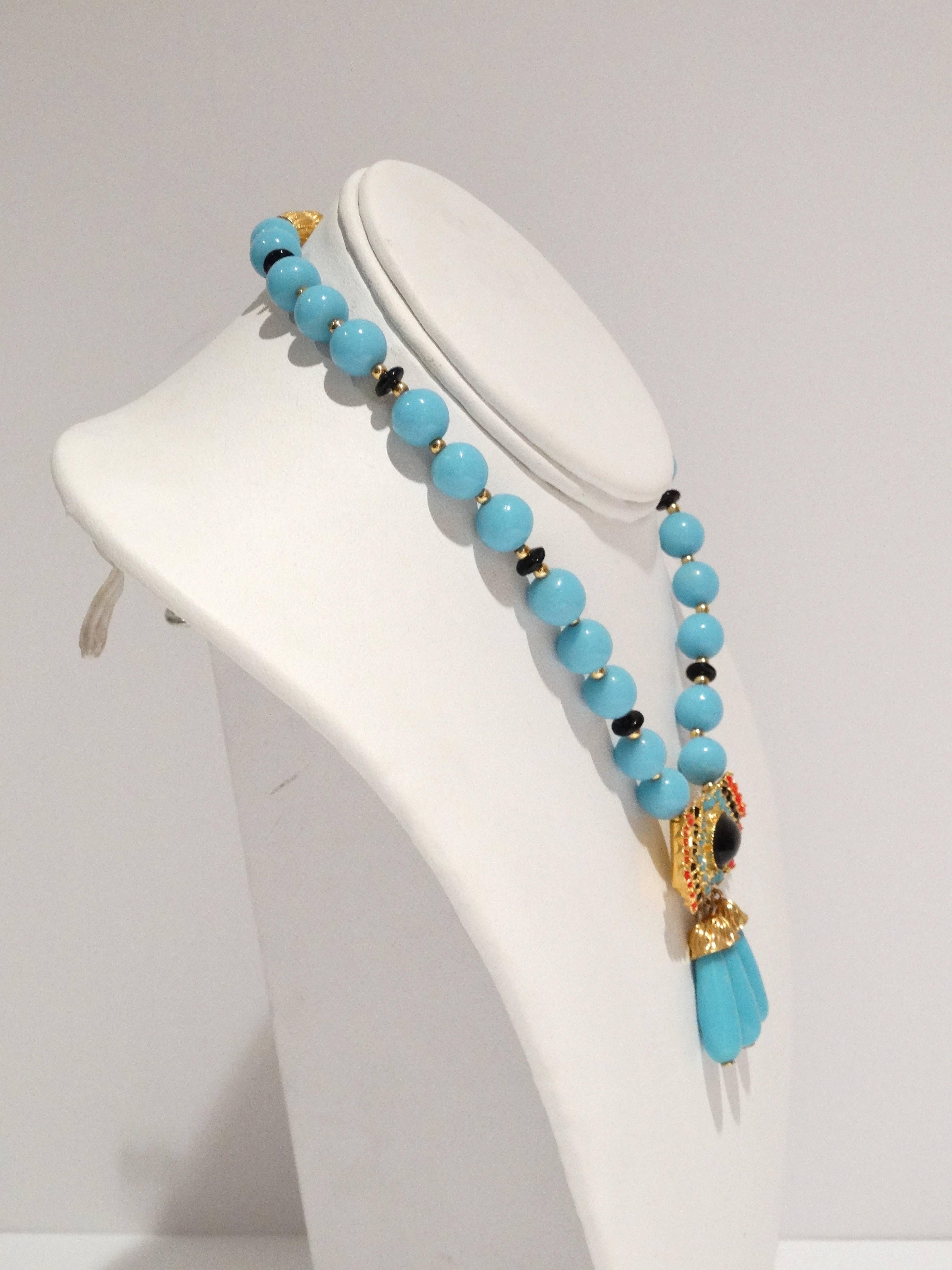 1970's William de Lillo tribal style necklace features beautiful turquoise glass beads along with small black and gold beads through out. Tribal style pendent has a large center black glass bead with small turquoise and red glass beads surrounding. 