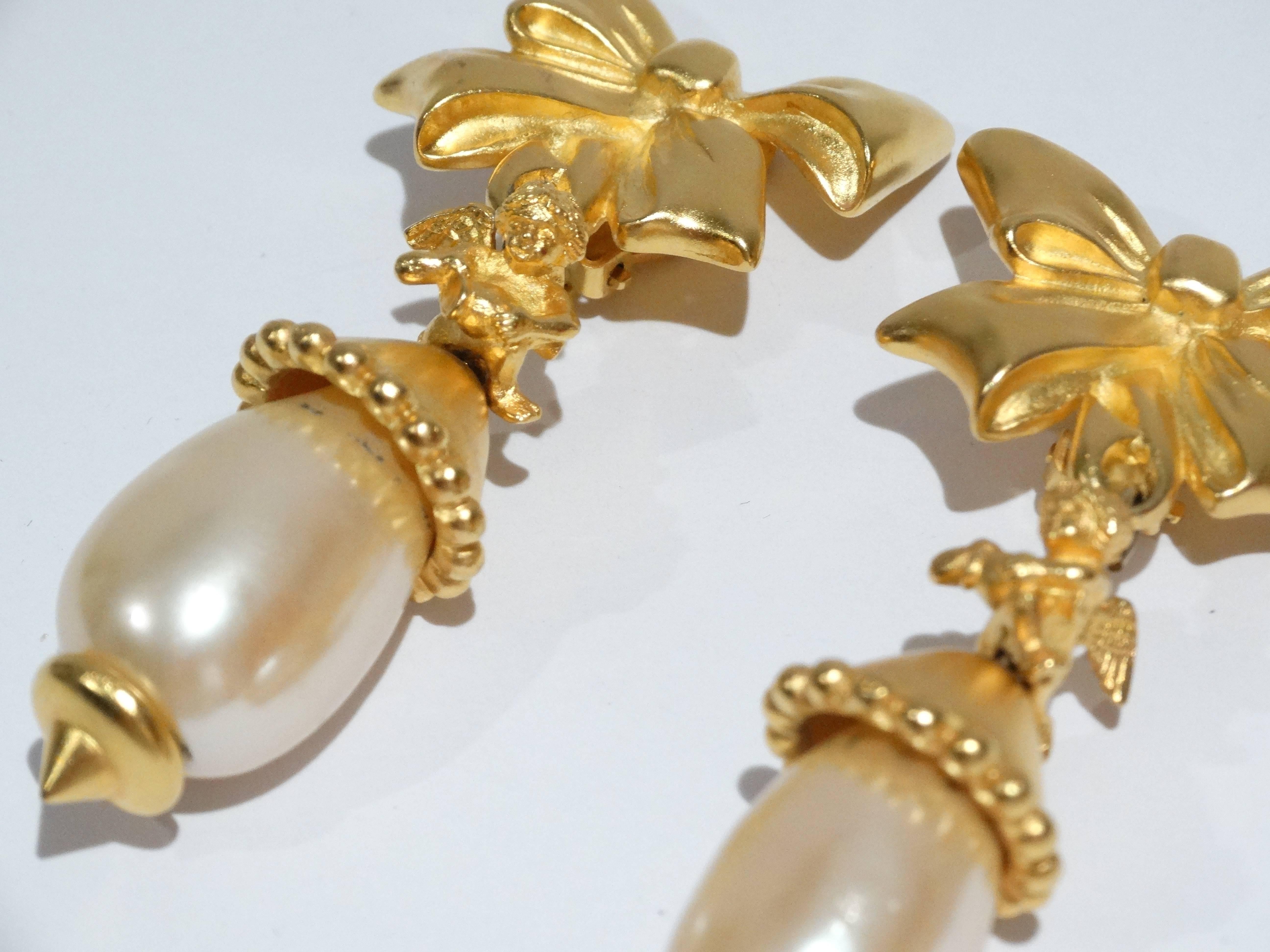 Rare 1980's Lagerfeld clip earrings with bow and cherub details. Large pearl drop set in gold guilt. Signed KL with a fan water mark of Karl Lagerfeld. 3.5 inches long and 2 inches wide. Great earring to take from day to night 