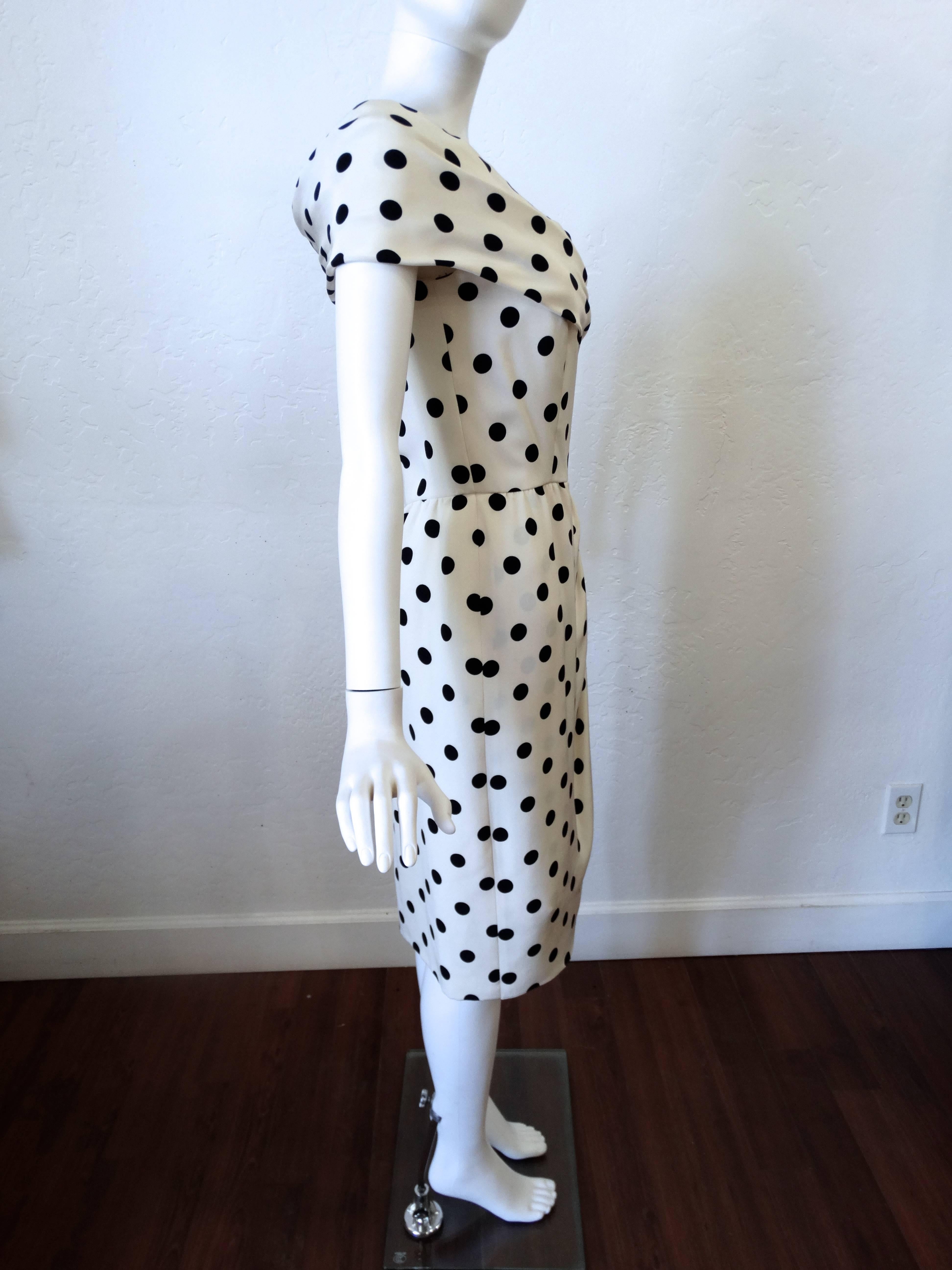 This is a gorgeous 1980's does 1950's Oscar de la Renta silk polka dot dress. Exquisitely constructed, the dress is fully lined with silk. The color is a winter white silk with black polka dots. Dress has a 1950's hourglass silhouette with a nipped