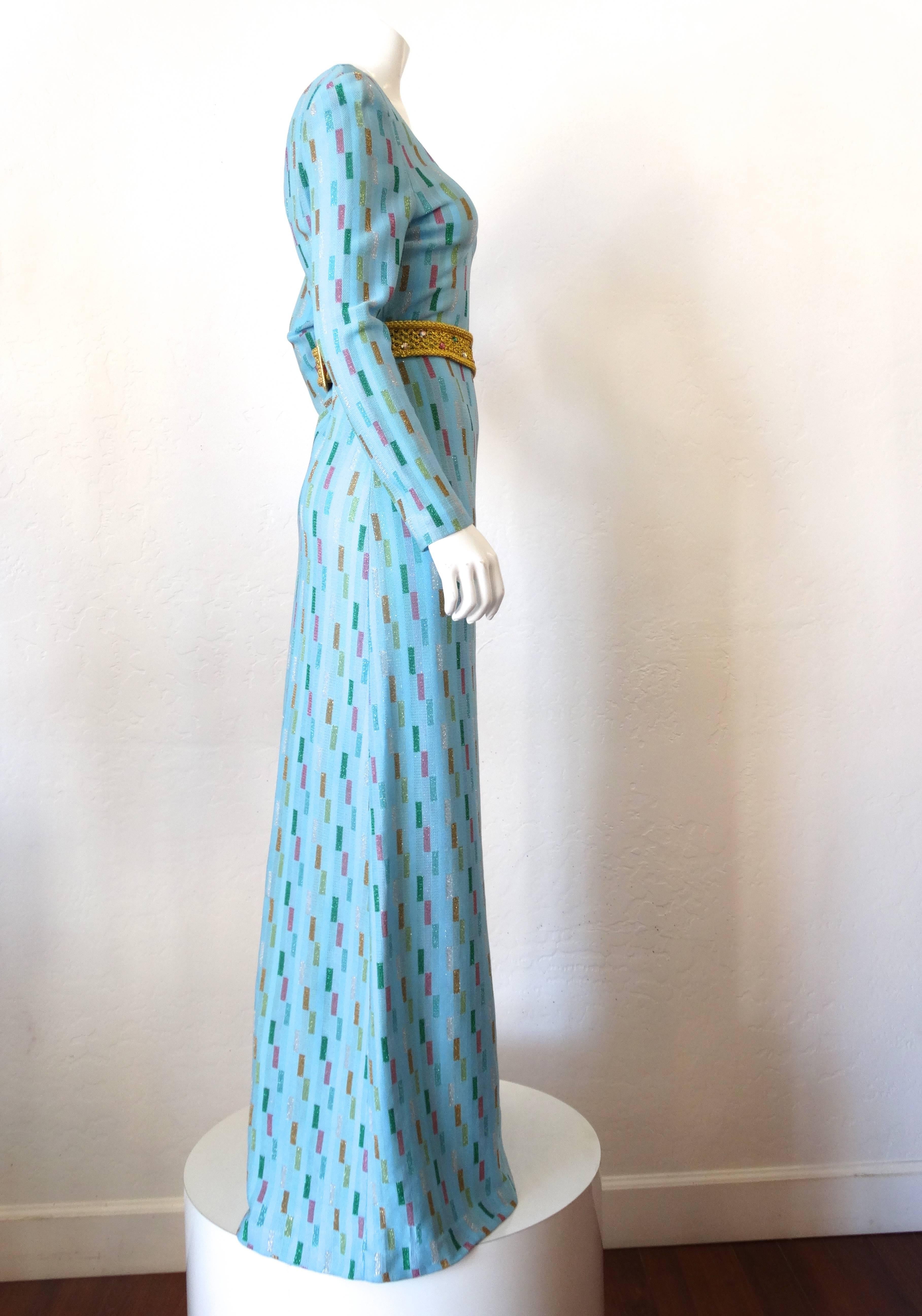 Simply stunning this beautiful 1970s closures super model length gown is in the most beautiful turquoise blue knit with a 3D rectangular. knit print in multicolored rectangles (green, gold, pink, silver and copper) with low cut front and back,
