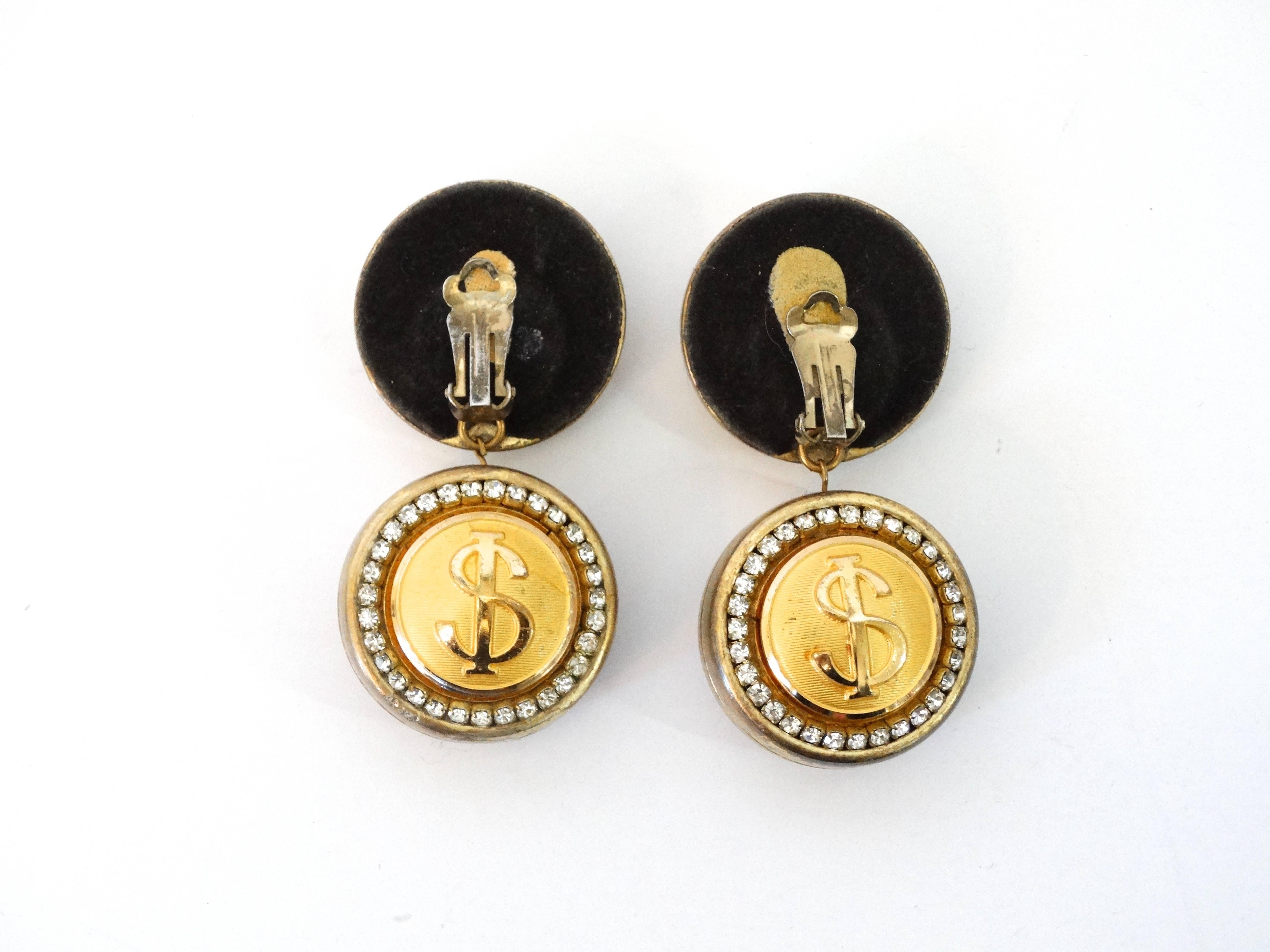 Funky cool 1980's Eric Beamon $ dollar $ symbol clip earrings. 4 round, 1 1/2 inches round charms make up this fabulous pair of earrings with rhinestones edges. 3 inches in length.  Eric Beamon designed, the back of the earrings have clips then
