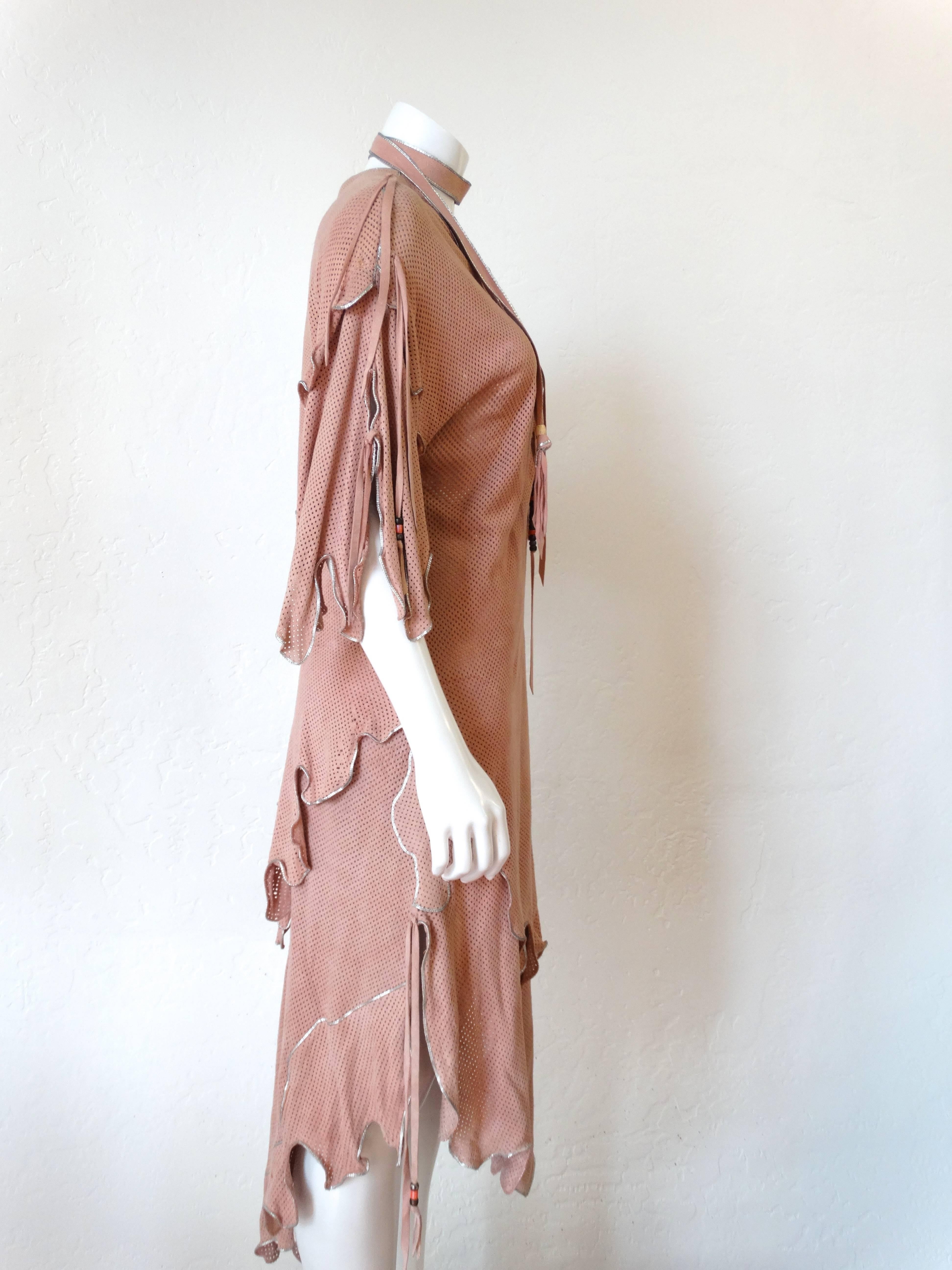 Spectacular early 1970's North Beach Leather Dress entirely hand-crafted with butter-soft perforated leather suede. The dress is meticulous detailed with silver trim that accents the layers of leather, sleeves and hemline. I love the look of this