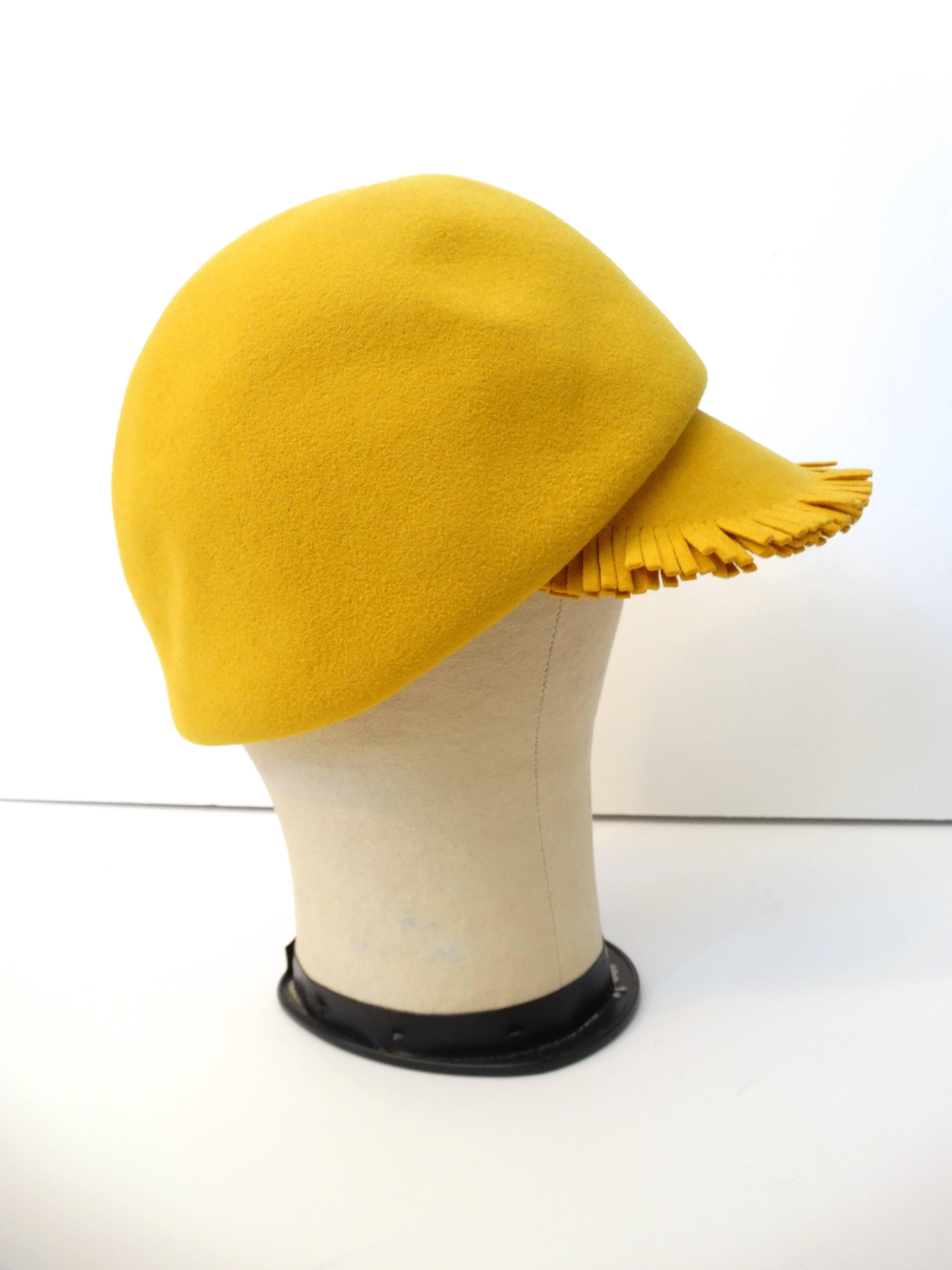 1960's melange blend felt bonnet cap by Henry Pollak for Mr. John Classic, in the perfect pantone prime rose yellow. Fringe trim cap with tonal wool ties. Ribbed interior lining. Size small , crown diameter 7