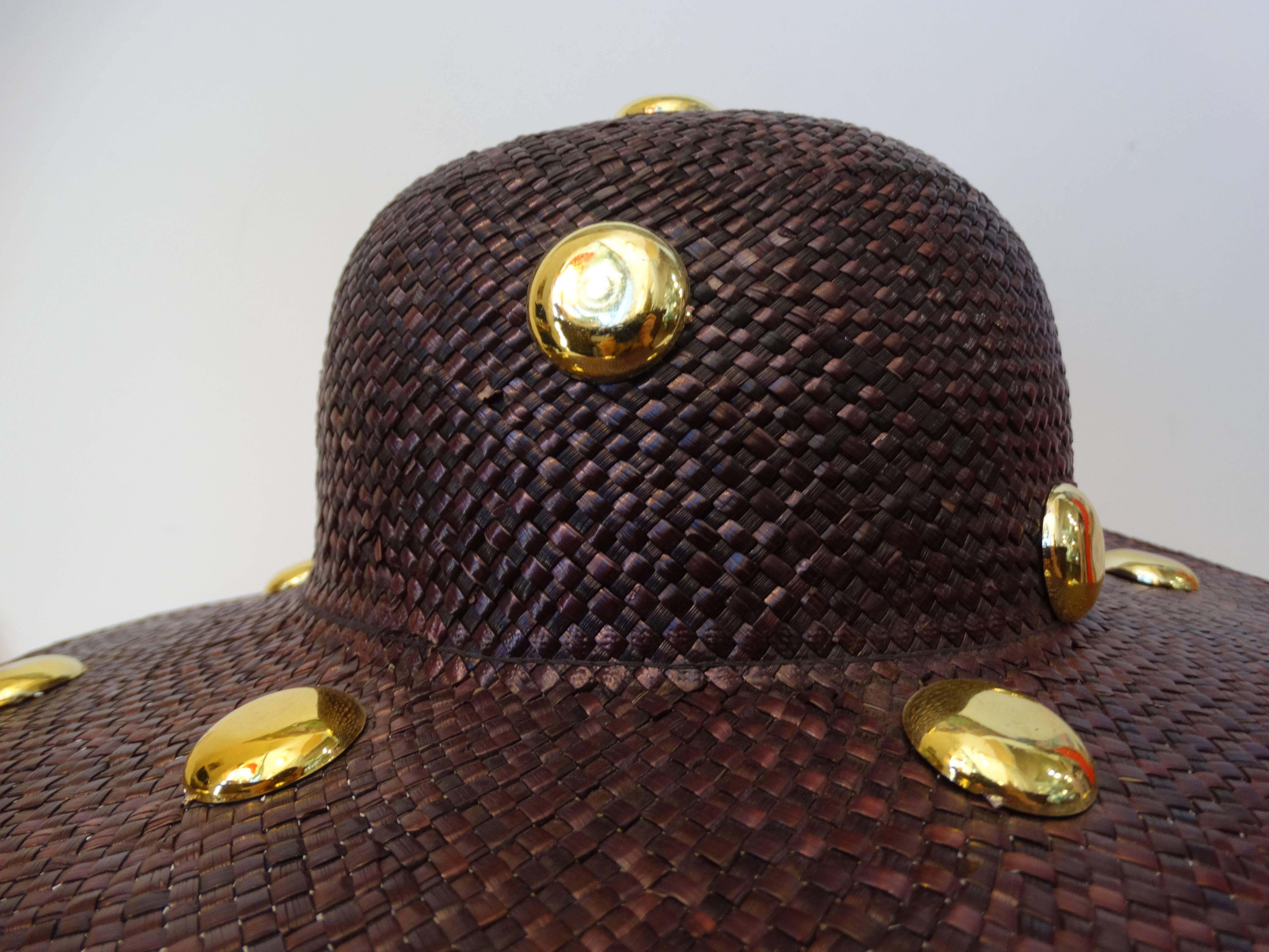 Fabulous 1980's Saks Fifth Avenue wide brim straw hat with large gold studs. Dyed deep purple. The base of the crown is plain with large plastic gold studs. The opening of the hat measures 21 1/2” around - this should fit a medium sized head. The