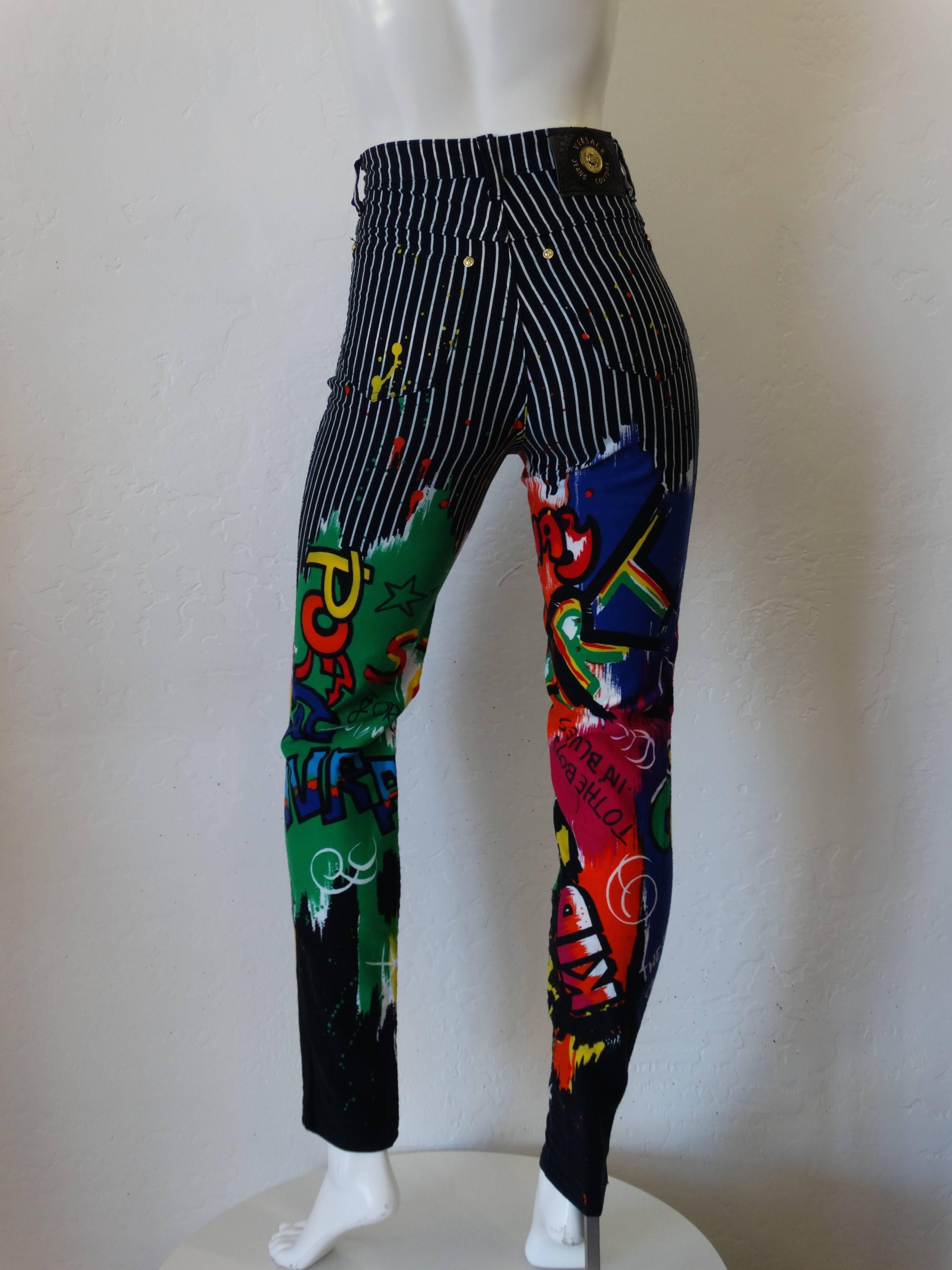 Amazing pair of 1990s Couture Versace Jeans! Bold black and white pinstripe print. Graphic multicolored graffiti with paint splatter accents. High rise with a tapered leg. Pants fit a sz 24 or 25 inch waist. Made in Italy 