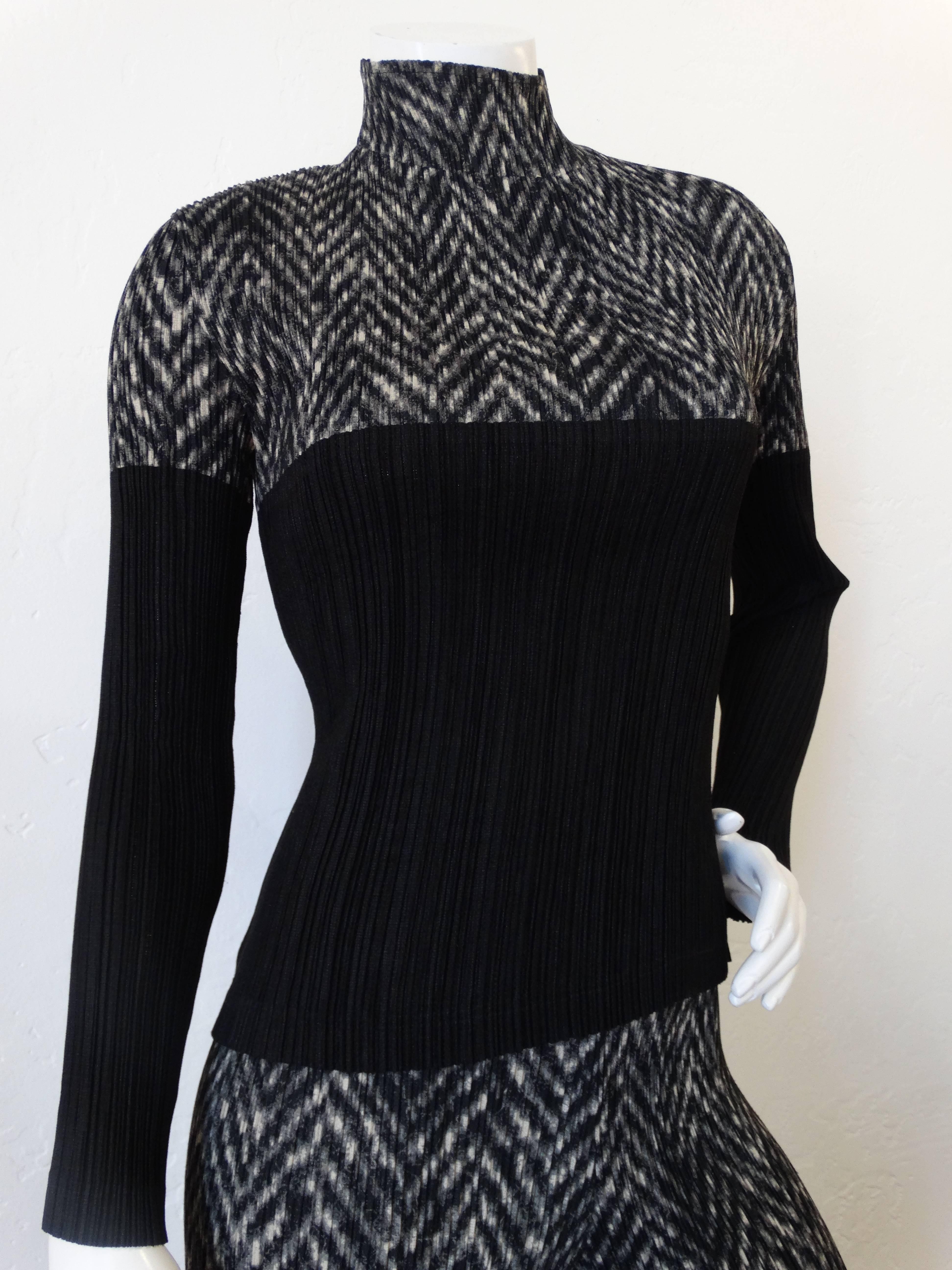 Incredible Issey Miyake matching set! Classic Issey micro pleats. Turtleneck style top with blocked chevron print. Tapered leg pant with a grey, white and black chevron print. Stretch waistline allows for a range of sizes. Made in Japan. Marked a