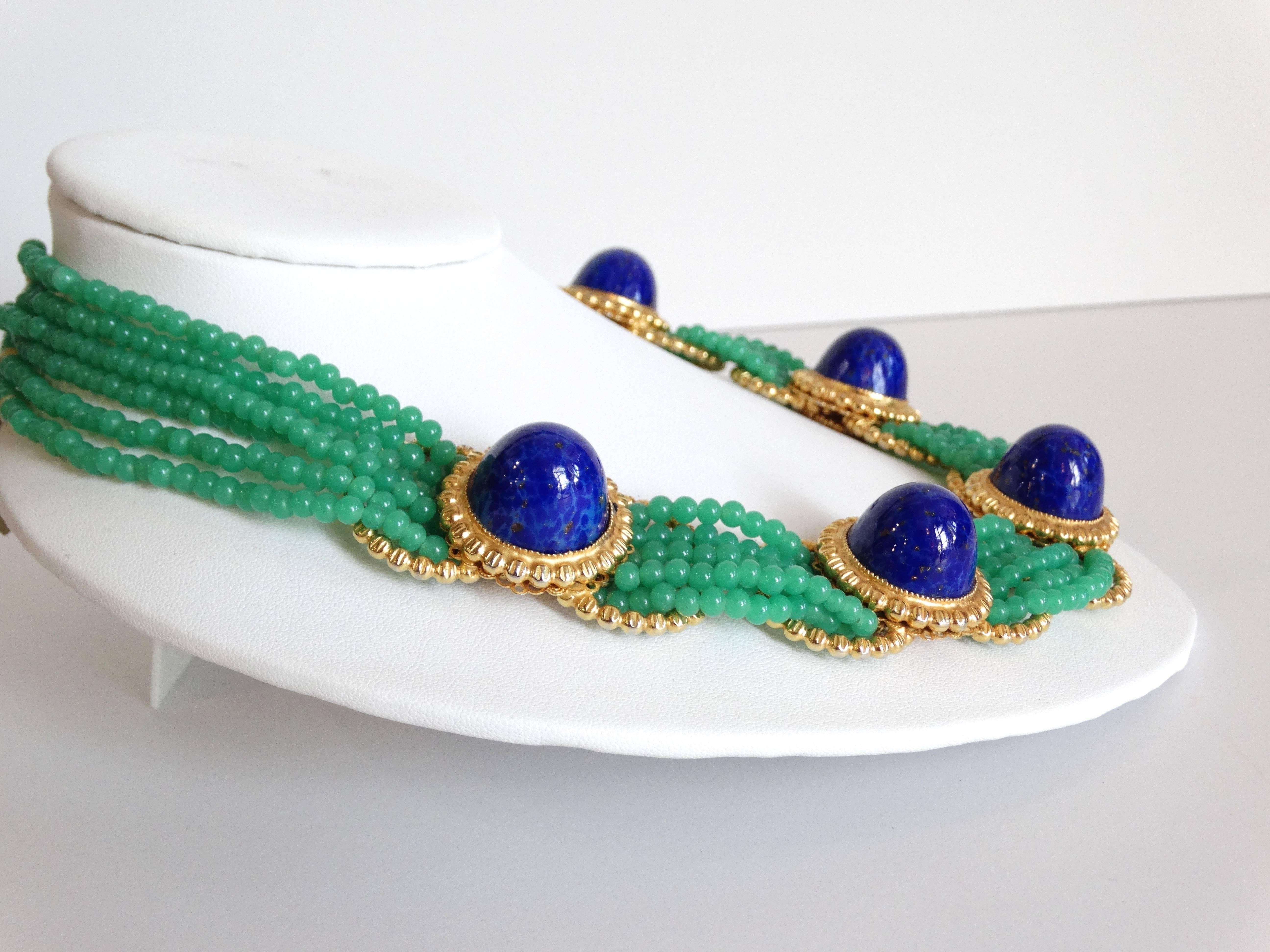 A beautiful collar necklace designed by William de Lillo in 1975. This beautiful collar necklace is designed with five large Lapis Lazuli stones set in a cabochon setting. 6 strands of small jade green cameo glass beads, come together to create this