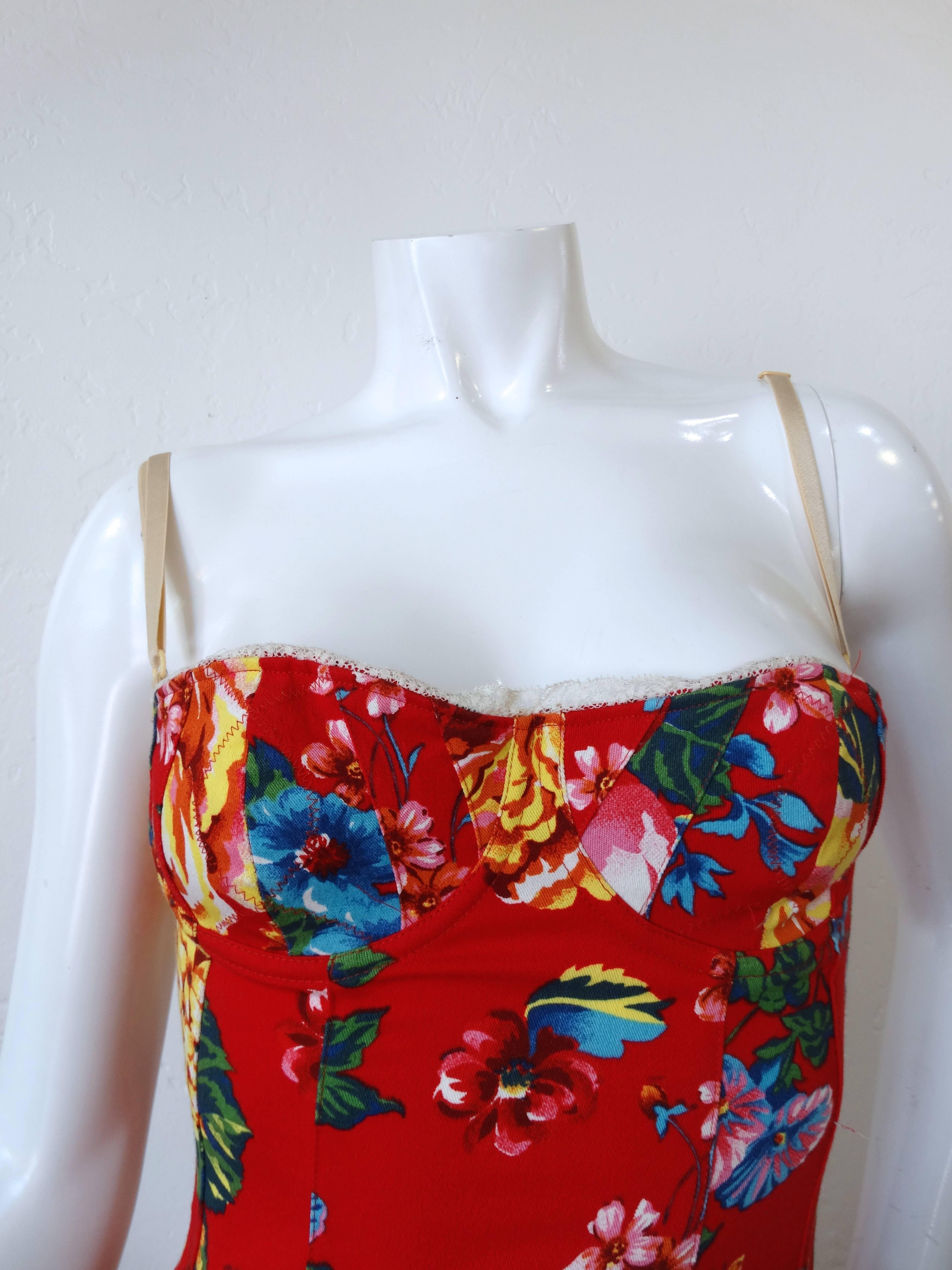 90's Dolce and Gabbana Corset Bodycon Dress. Bold graphic cabbage rose floral print. Non functional hook and eye details down the back add to the corset look. Cream lace trim along the bustline. Adjustable straps. Zips up the side. Marked a size 44.
