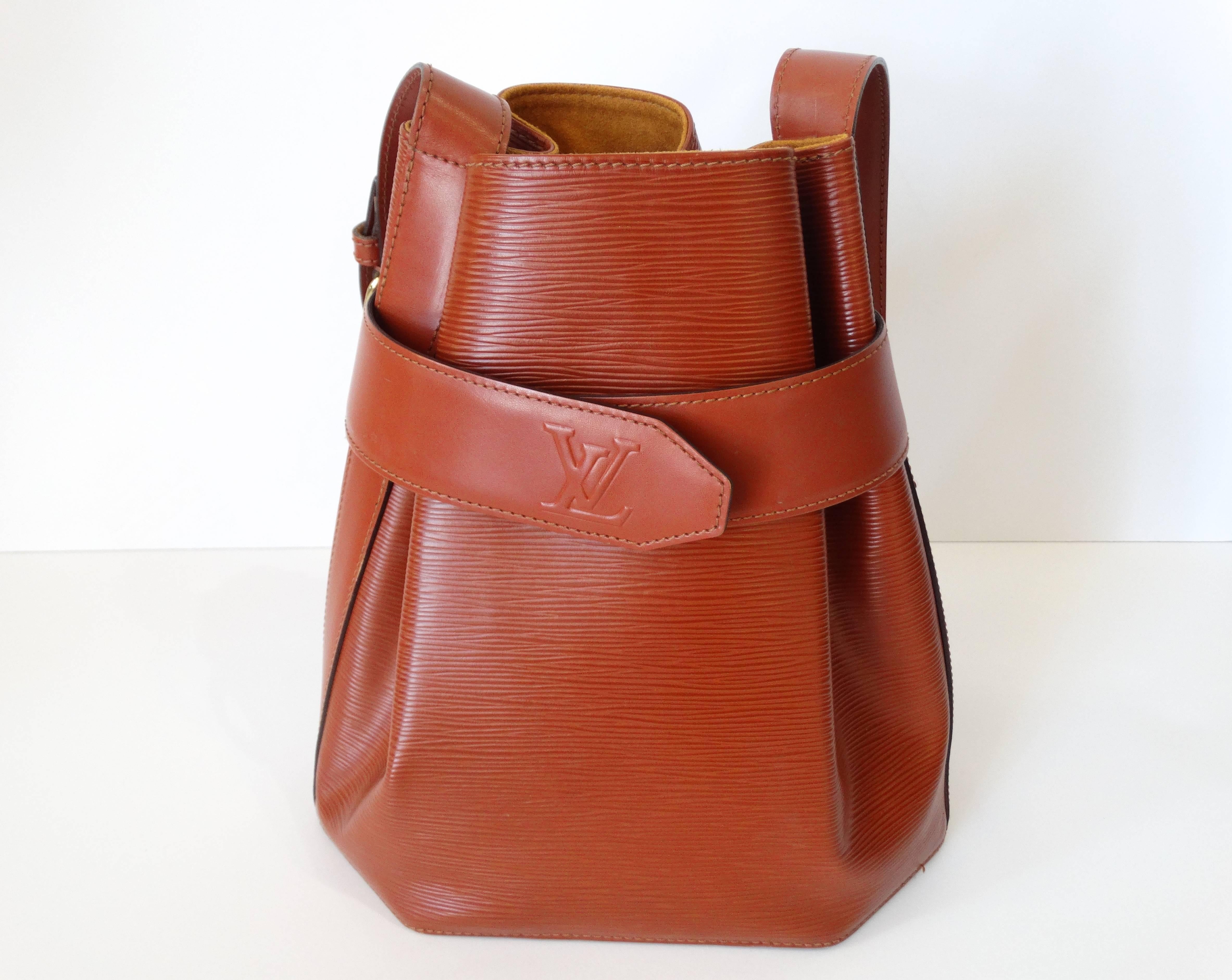 Early 1990's Louis Vuitton shoulder Bag in Tan Epi leather, bucket bag style. Louis Vuitton embossed logo on the snap buckle. Made in France. 100% EPI Leather. Matching suede Tan interior. The inside is in new condition and the exterior is in