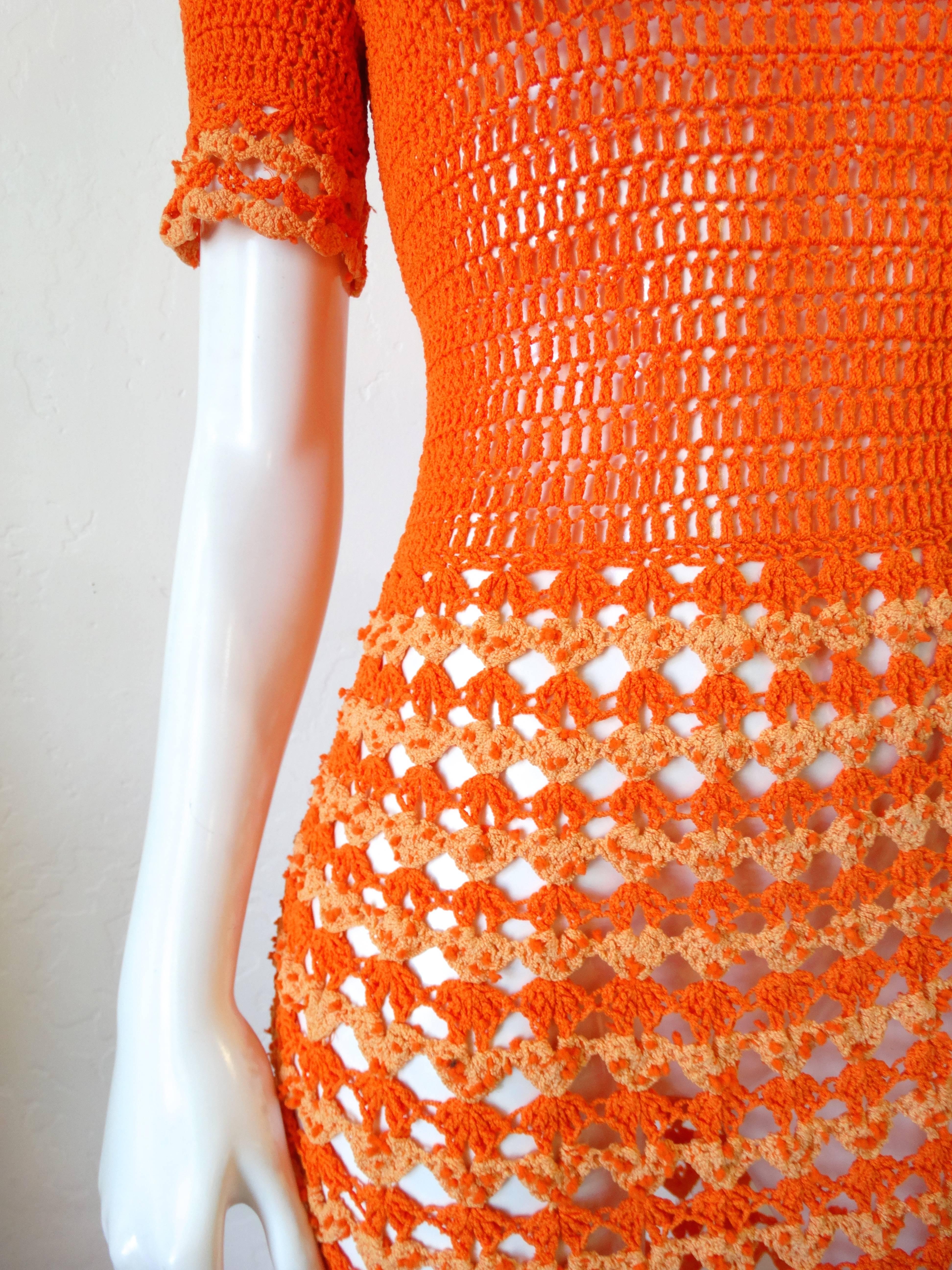 Incredible 1970's orange knit gown! Vibrant two-tone orange tighter knit on the top with a more open crochet fabric from the waist down. metal zipper that zips up the back. Crochet ruffle neckline and sleeve! Even better in person.
