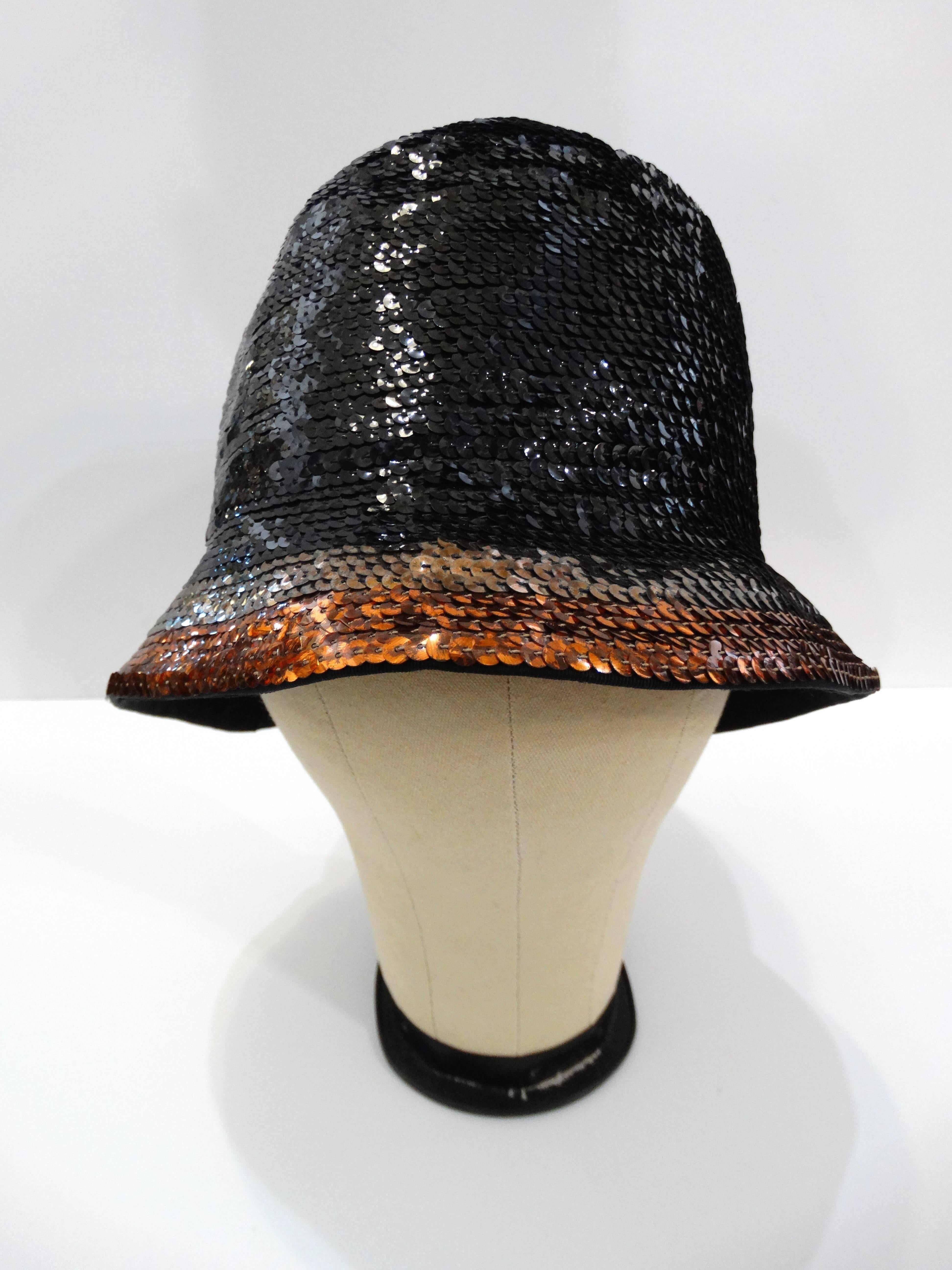1970s ultra glam sequined hat by Yves Saint Laurent. Beautifully done in a black woven straw base that's fully covered in black sequins on the body and two wide stripes of metallic grey and copper colored sequins around the brim. Classic fedora