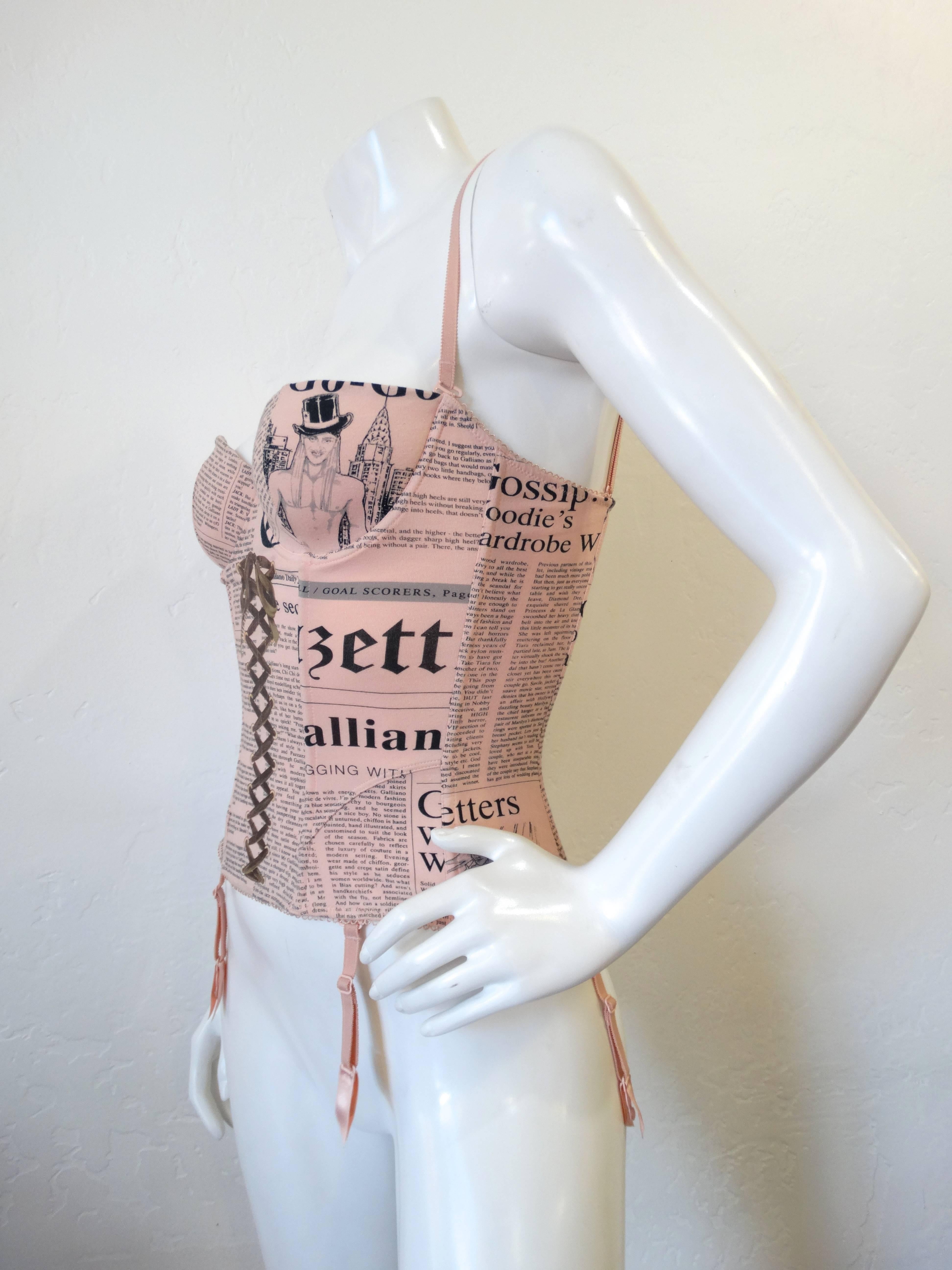 The sexiest little Galliano Newsprint Corset in soft baby pink! Stretchy cotton with boned interior and detailed stitching. Garter straps and shoulder straps are detachable as well as adjustable. Best fits an XS/S- A cup maximum. 