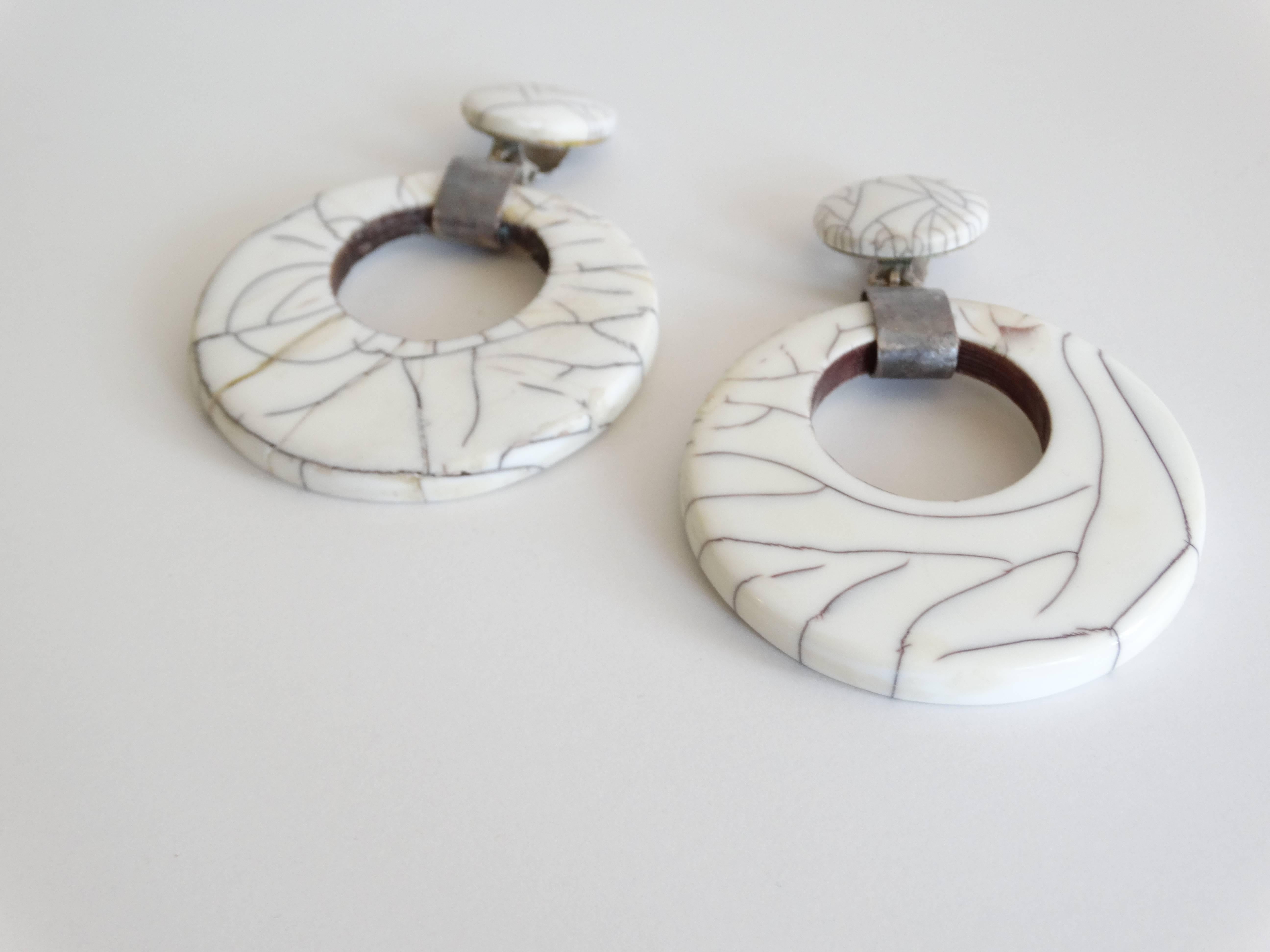 Fabulous Large Hoop Earrings designed by Premier Etage Paris in the mid-1980's. Made of a marbled white resin with silver hardware. Clip ons and light in weight. A great statement earring sure to turn heads. 

Measurements:
4