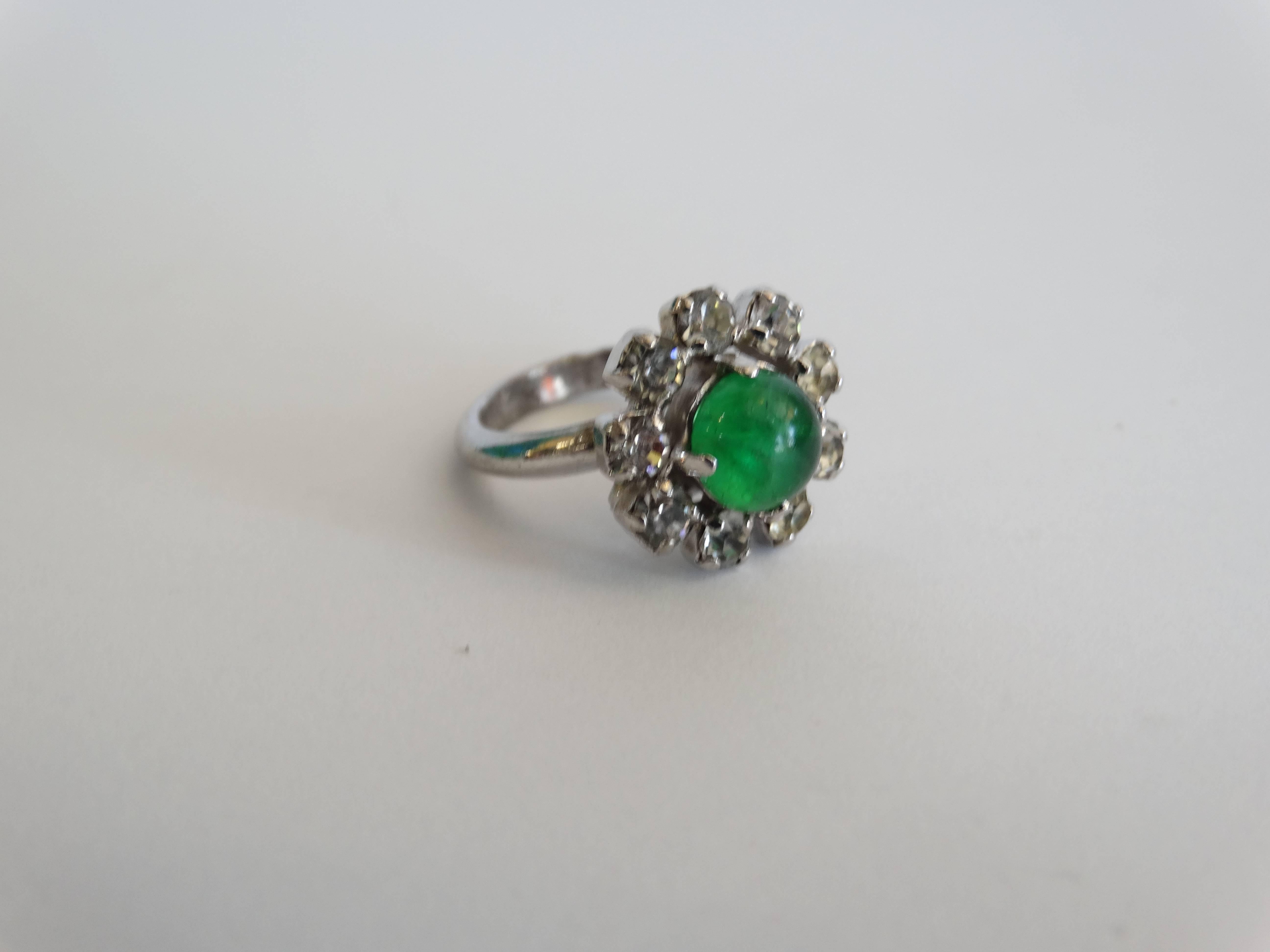 A beautiful cocktail ring designed for Christian Dior by Henkel and Grosse! Diamante and Emerald ring features 9 settings of diamanté and one glass emerald center stone.  signed Chr Dior, C, Germany, 1969 Reference: Mark dates this to 1969, and