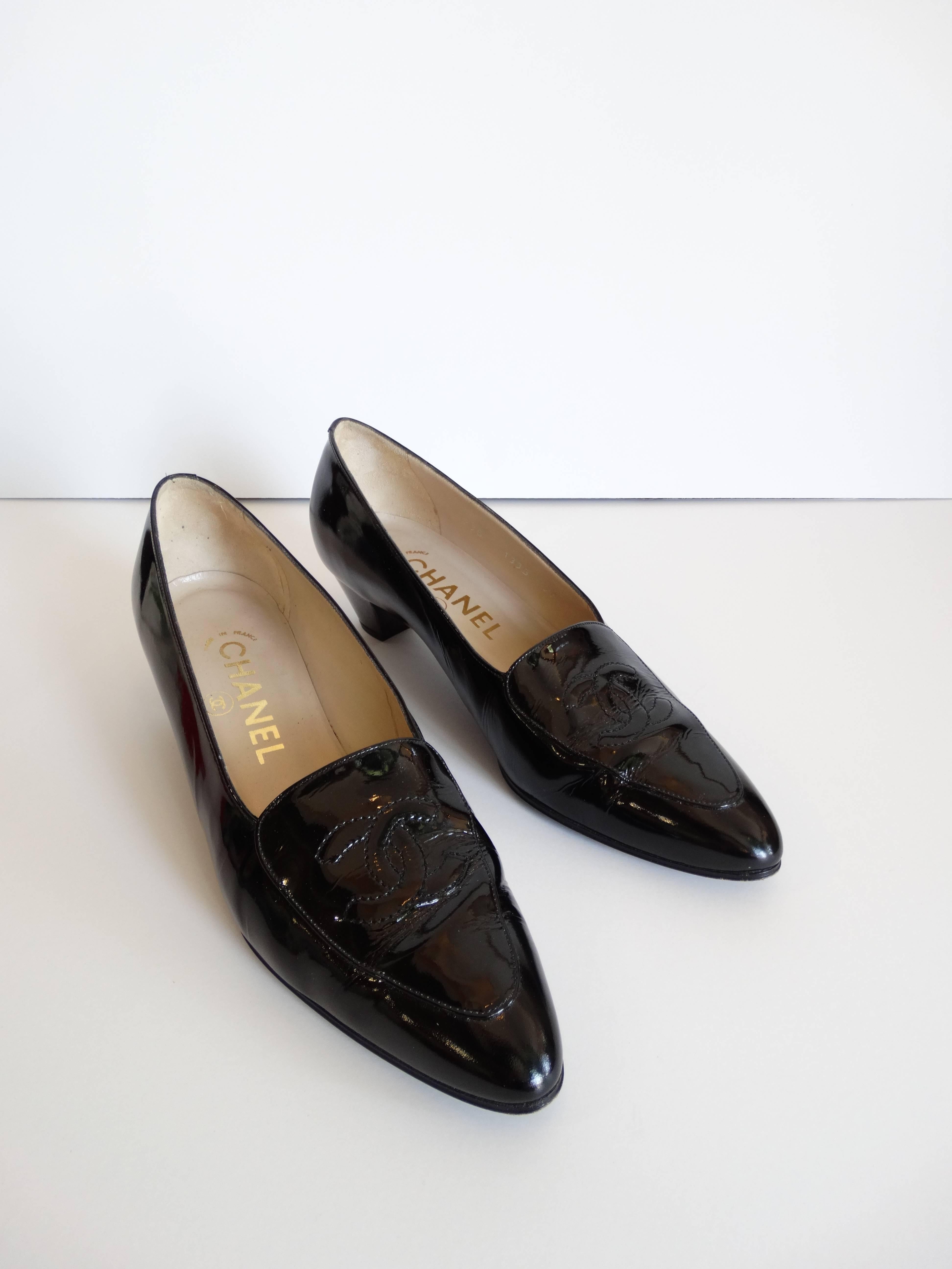 Incredible pair of 1990s Chanel black patent kitten heel loafers! Short kitten heel with pointed toe. Signature Chanel logo stitched atop the toe. Marked a size 37. Light scuffs on the bottoms, as pictured. 10 1/2 inches from toe to heel. Made in