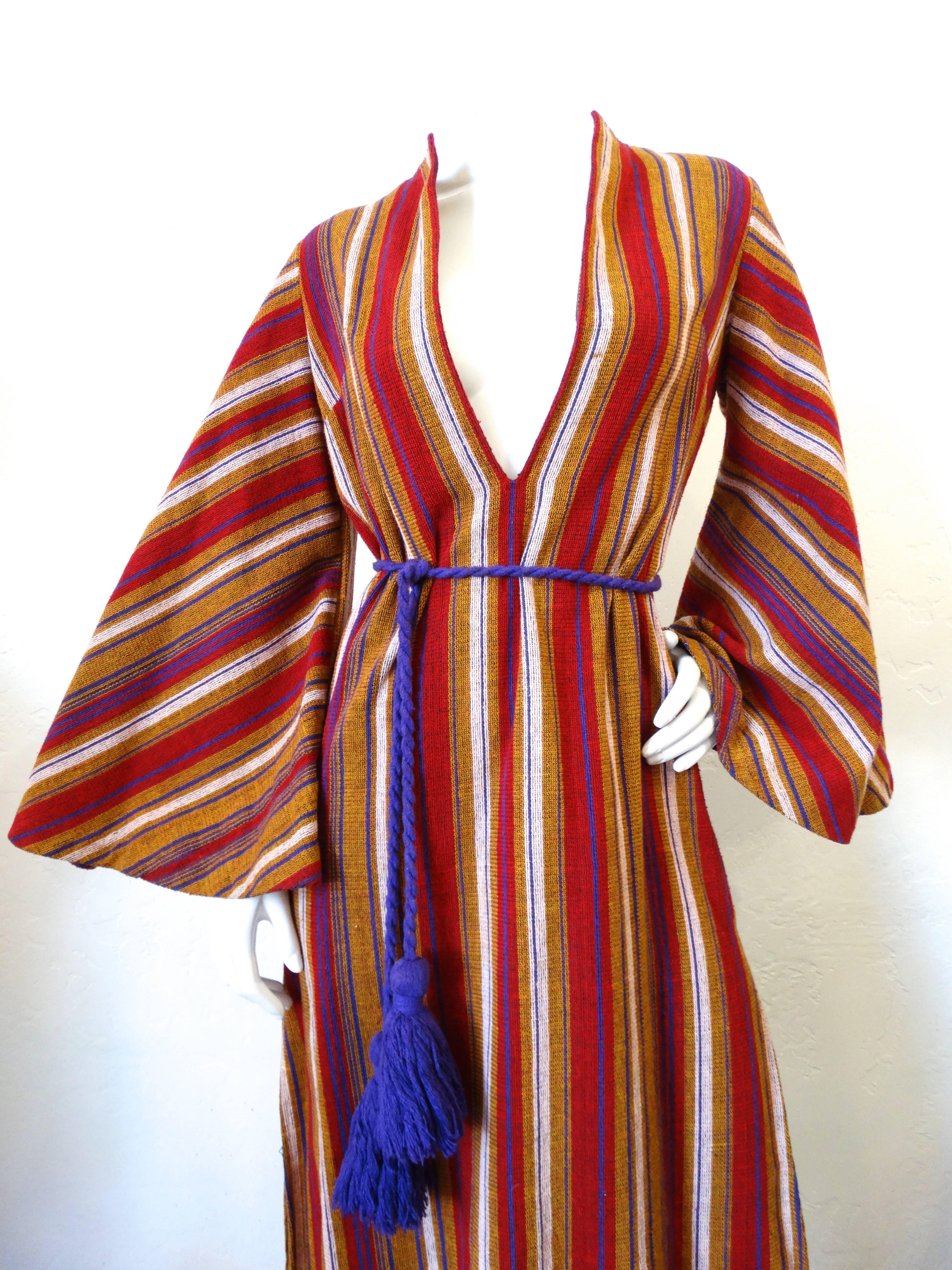 Incredible 1970s Rikma maxi dress! Made of woven cotton in a multicolored stripe print. Purple yarn tassel cinches the waist perfectly just below the deep V-neckline. Large bell sleeves with side splits on each side of the dress.  Fits about a size