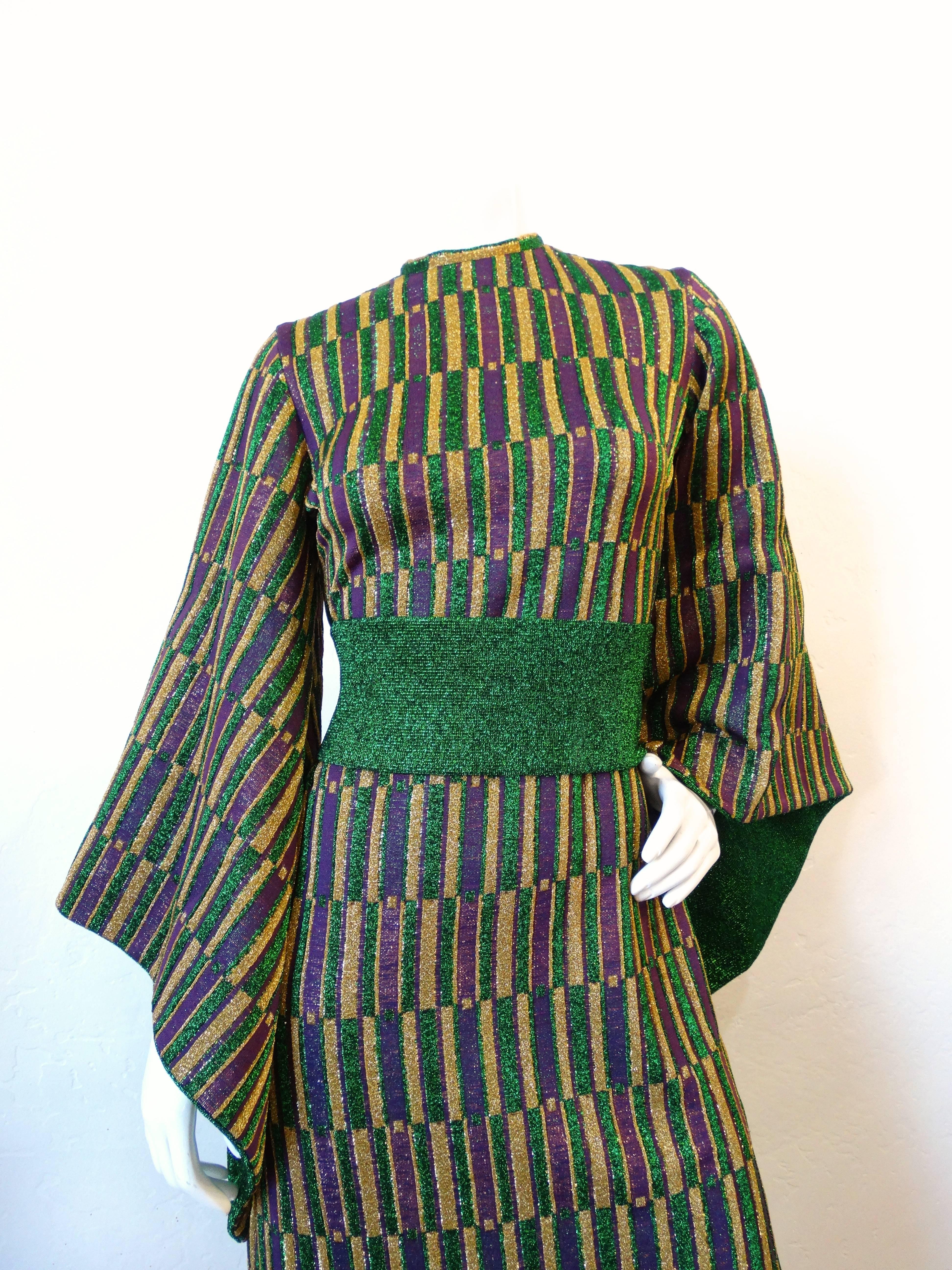 Incredible 1960s maxi gown- designed by Aled Couture of Israel! Dramatic angel wing sleeves, backed with green glittery fabric. Made of a metallic knit with purple, green and gold geometric print. Waist cinches with a green sash that buttons up the