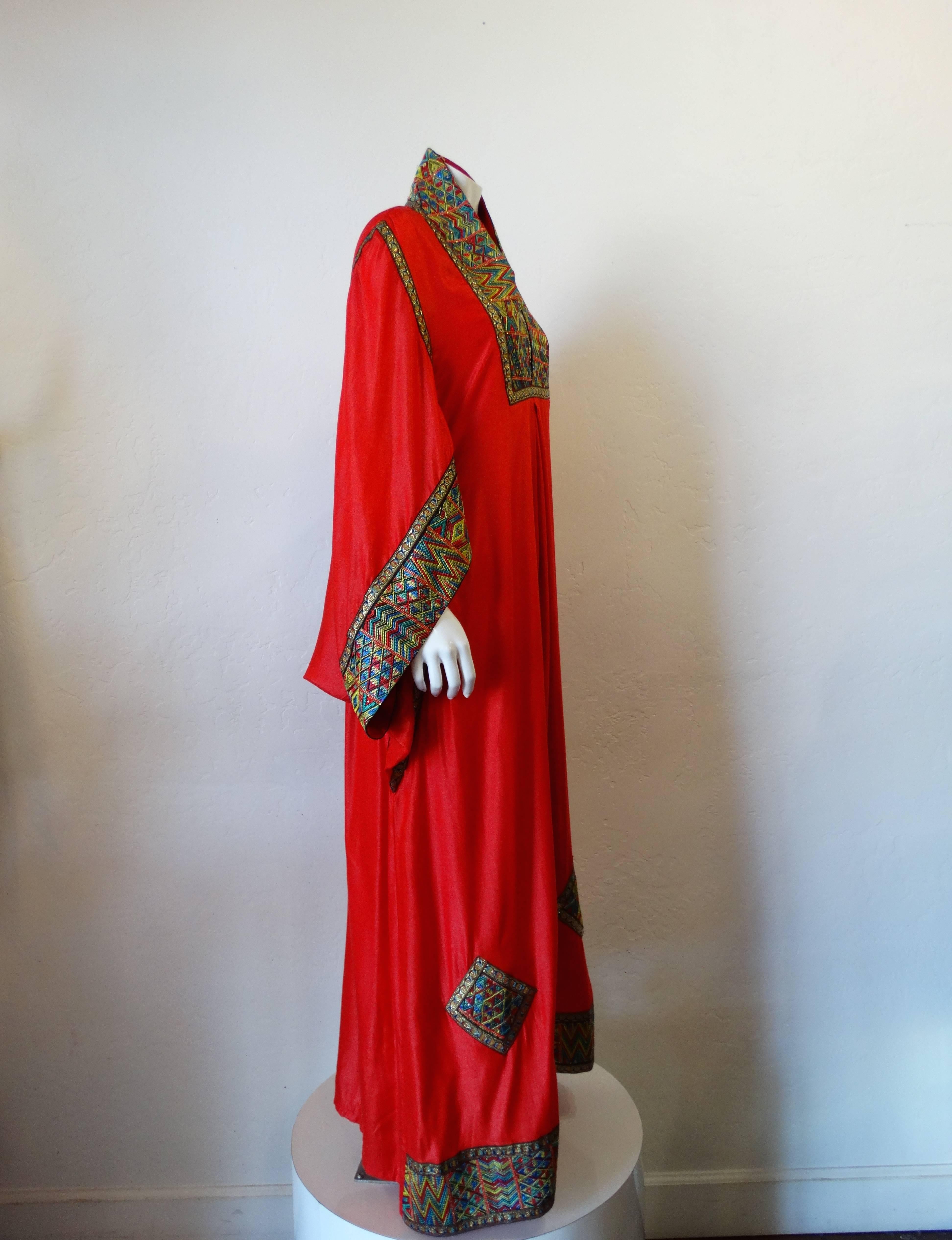 Incredible Israeli gown from the 1970s- designed by Nersyan. Made of brilliant fancy abaya red with multi color woven appliqué with multi color micro sequin elements with rainbow geometric patterns. Cocoon sleeves and high neckline add to the