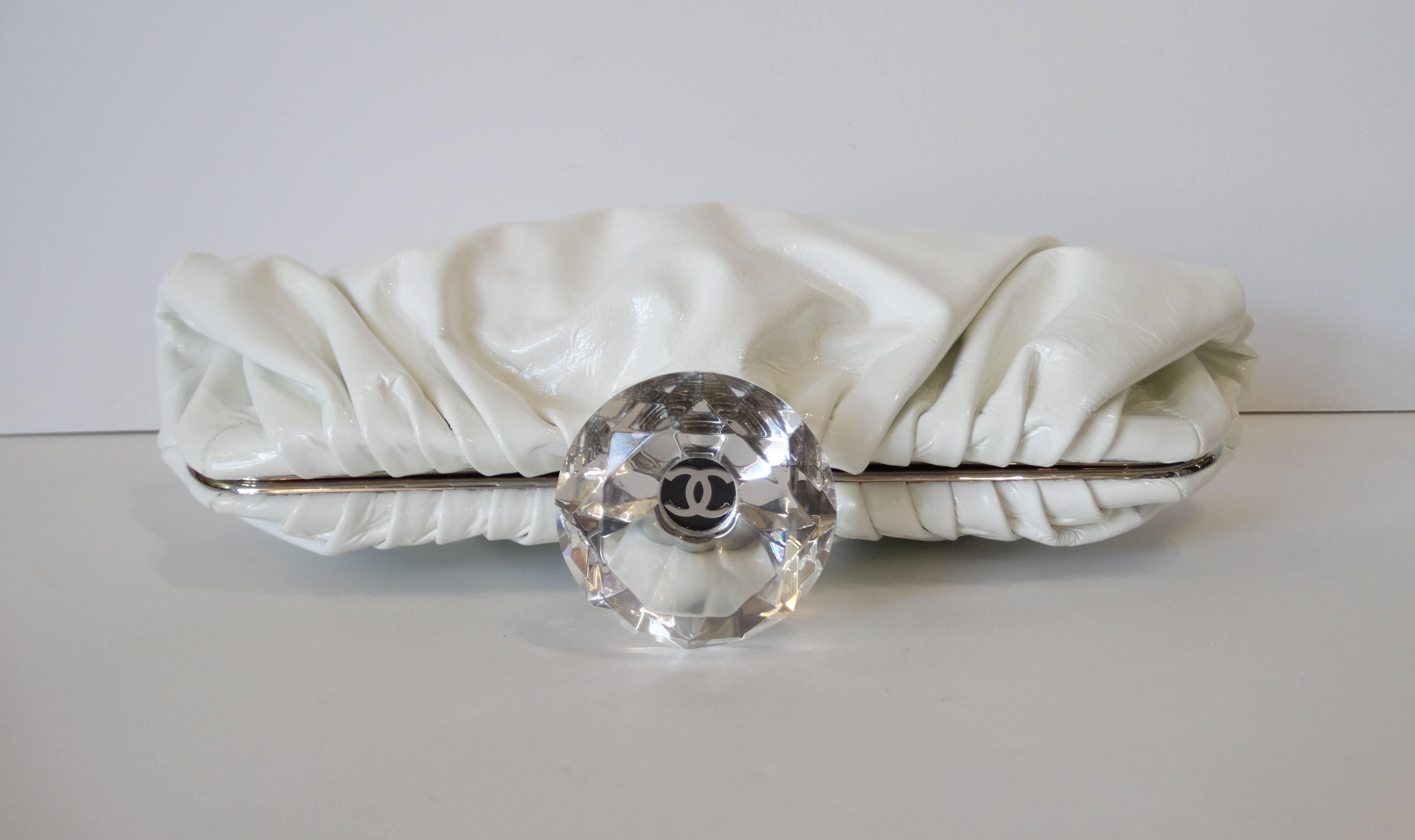 Forget the Hope diamond- we want Chanel diamonds! This incredible clutch comes a soft and shiny white patent leather- accented with silver hardware and of course: an oversized lucite diamond with CC logo in the center. Push lock closure at the top.