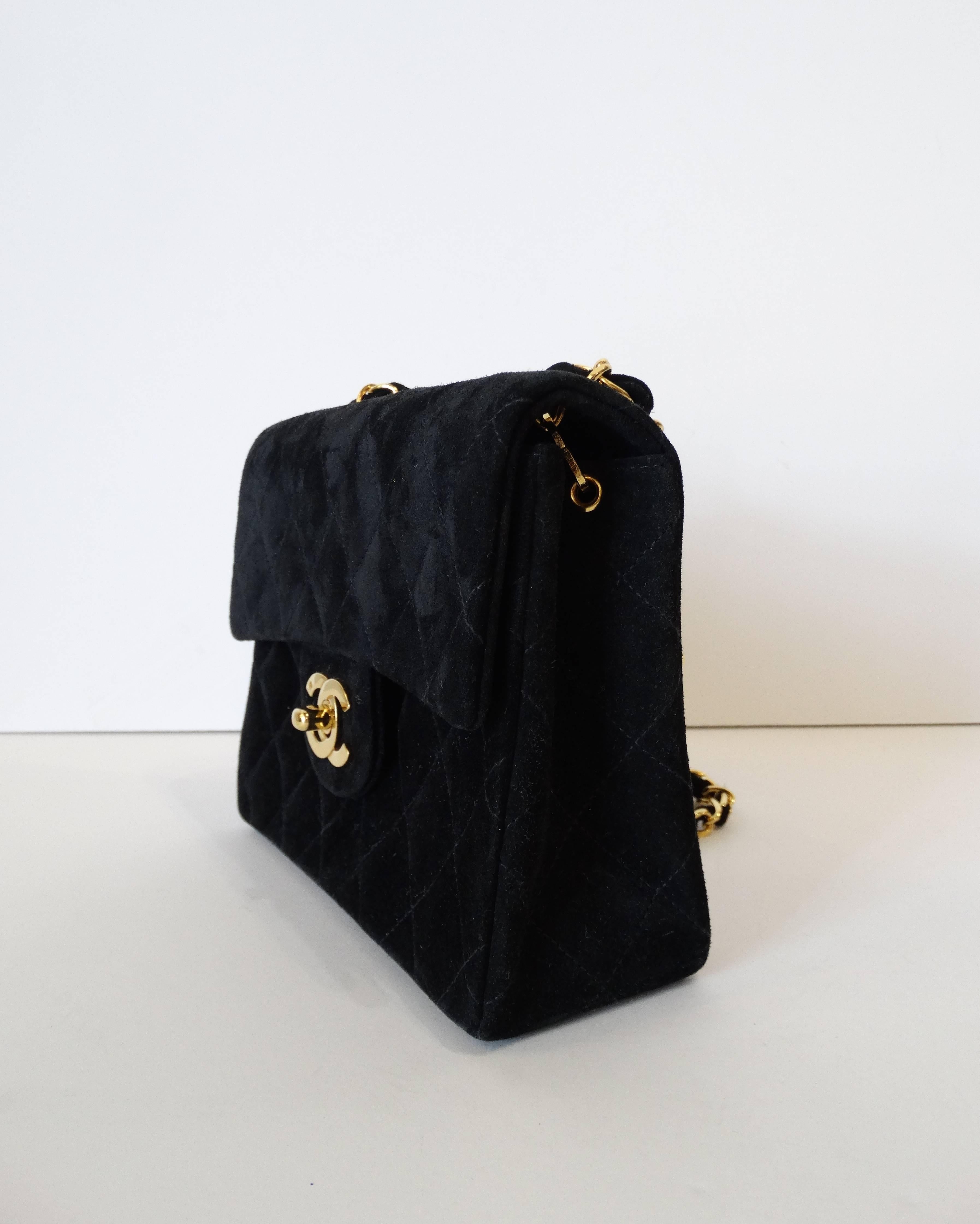 A quilted black Chanel bag is a must have! Classic and versatile- this amazing 1990s Chanel bag comes to you in a rich black suede. Quilted with  Accented with gold hardware, CC turn lock closure and the iconic gold chain strap. Comes with original