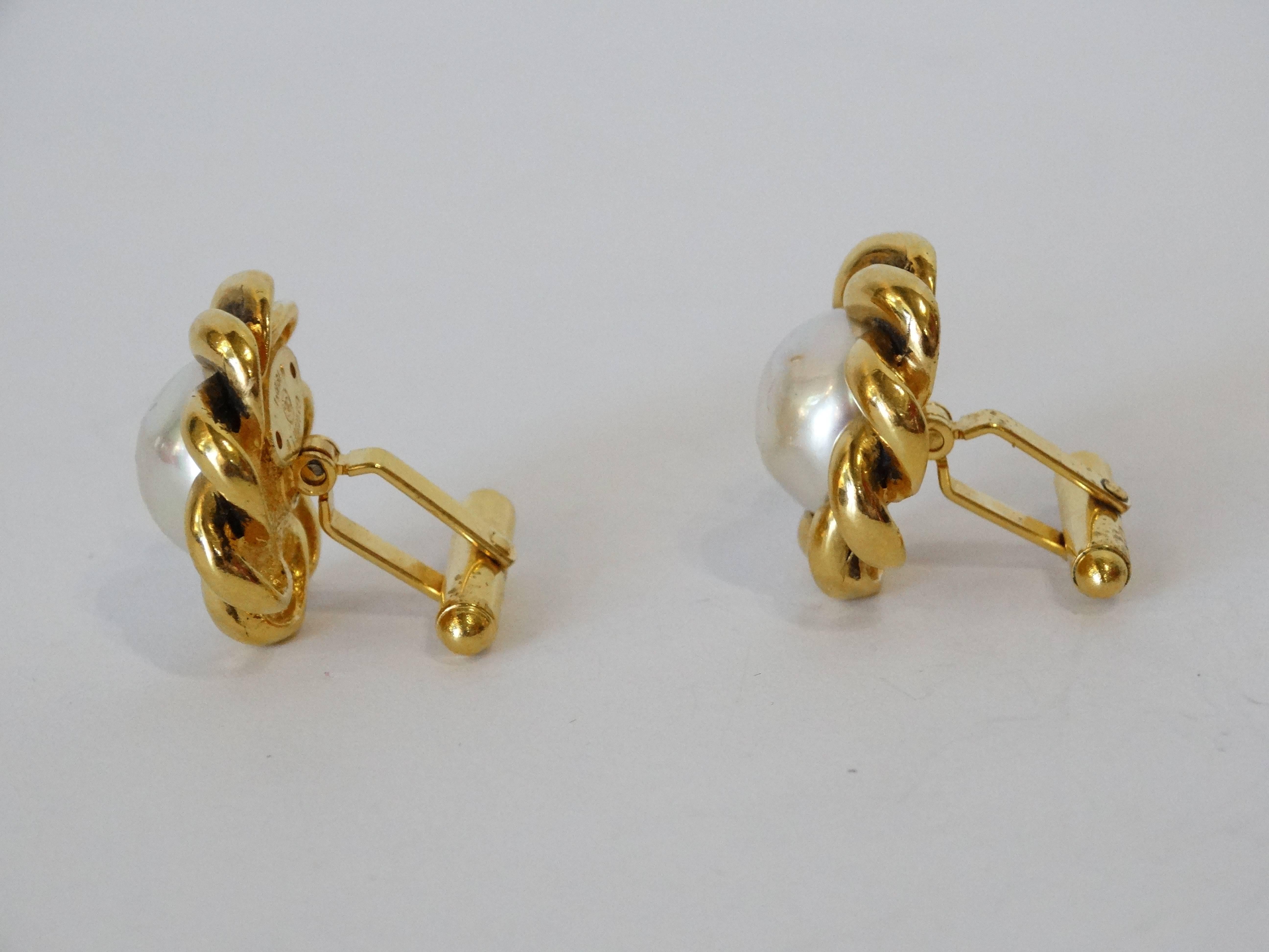 An incredible pair of Chanel cufflinks straight out of 1984! Braided design cast in gold metal with large faux pearls at the center. Signed Chanel 528 and plated at the back of both piece. About 1 inch in diameter.