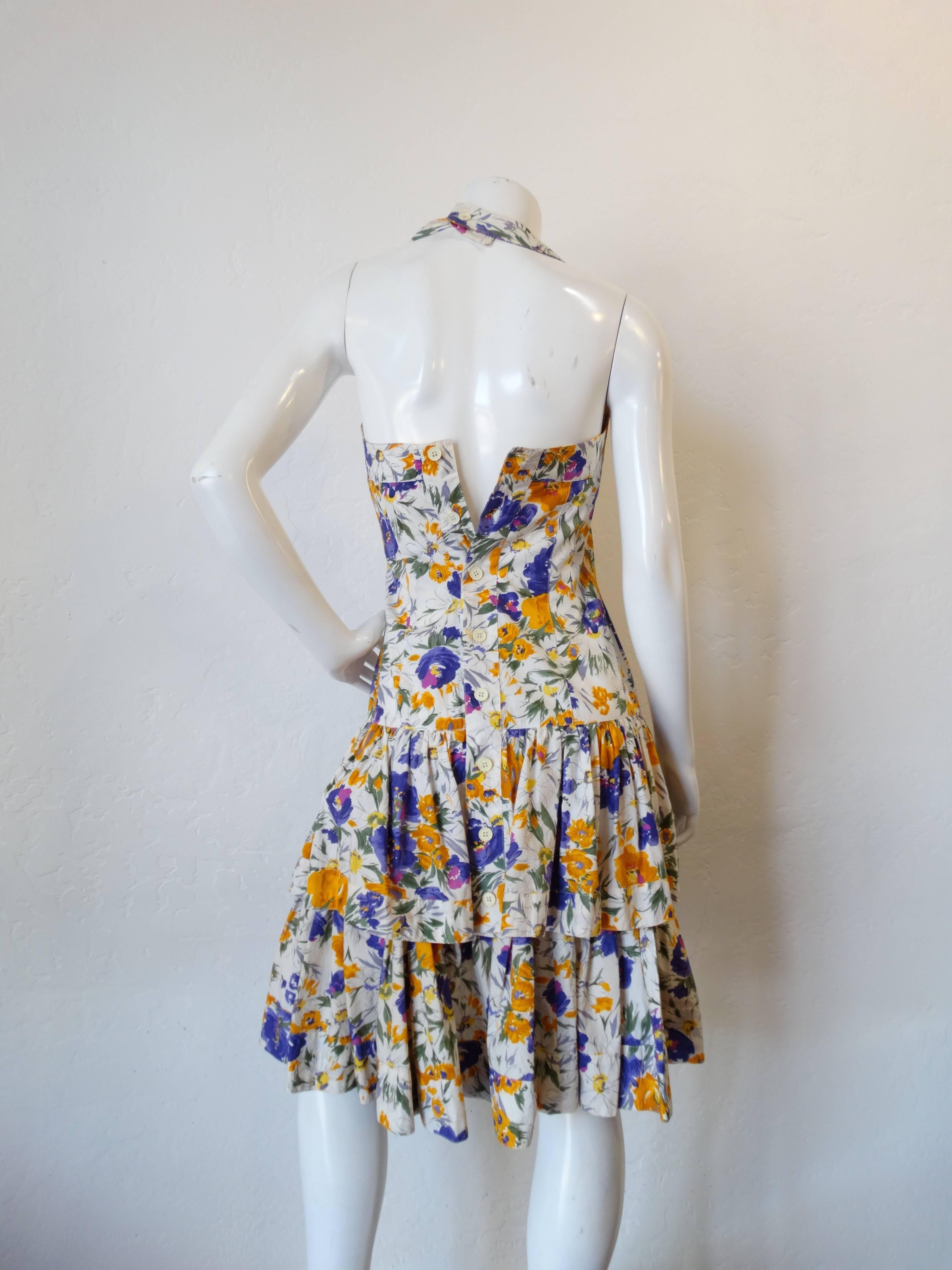 Amazing 1980s/90s hard to find Ted Lapidus haute couture floral dress! Floral printed cotton with slim fitted bodice and flounce layered ruffle peplum skirt. Halter straps with button closure at the back of the neck. Buttons up the back. 
Modern