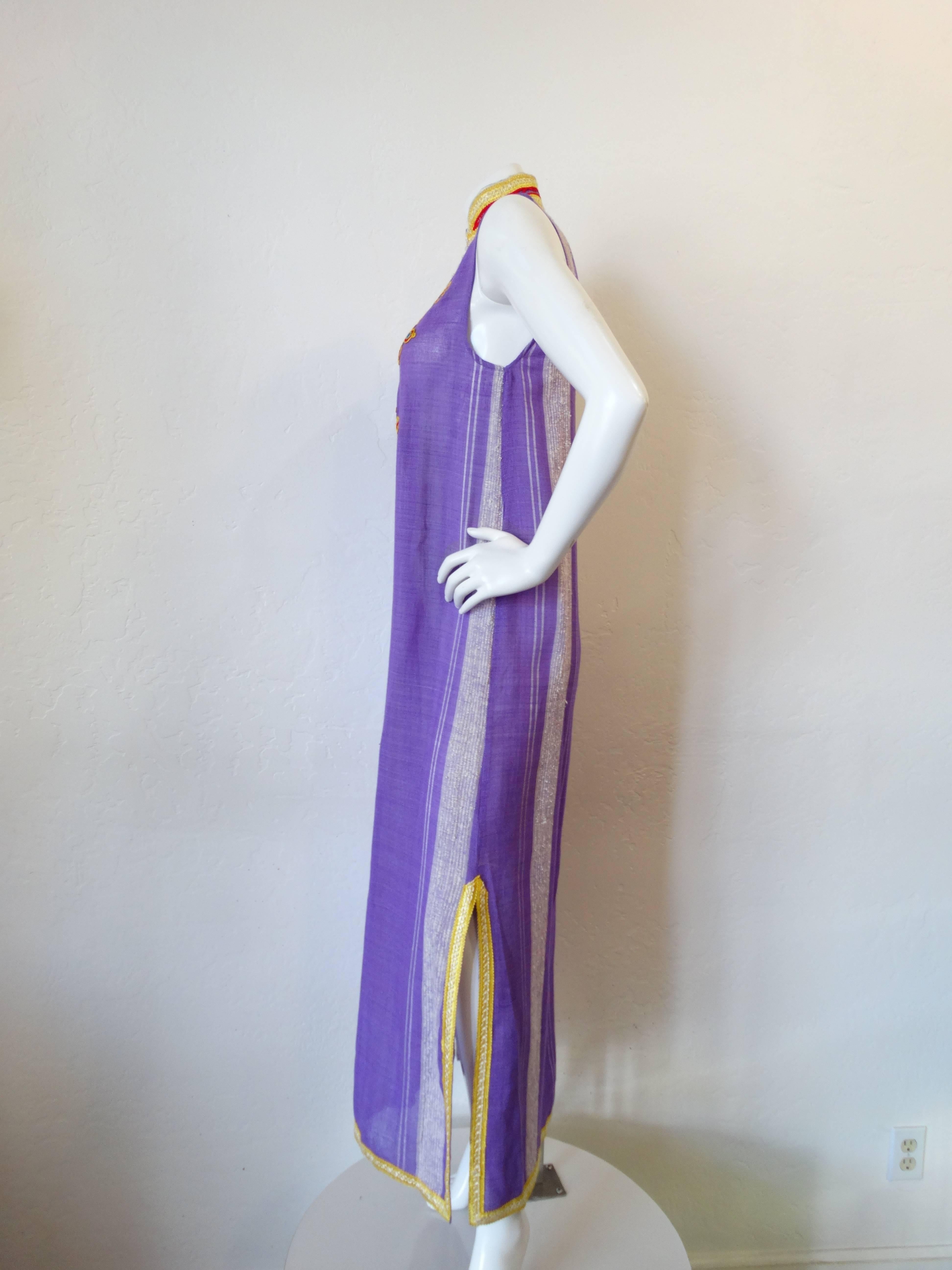 Incredible 1970s sleeveless dress from designer Glenn Mark of Boston Breathable sheer woven cotton in a brilliant purple color. Accented with primary colored embroidery along the neck and bodice. Buttons up the bust. Marked a size Small. 
