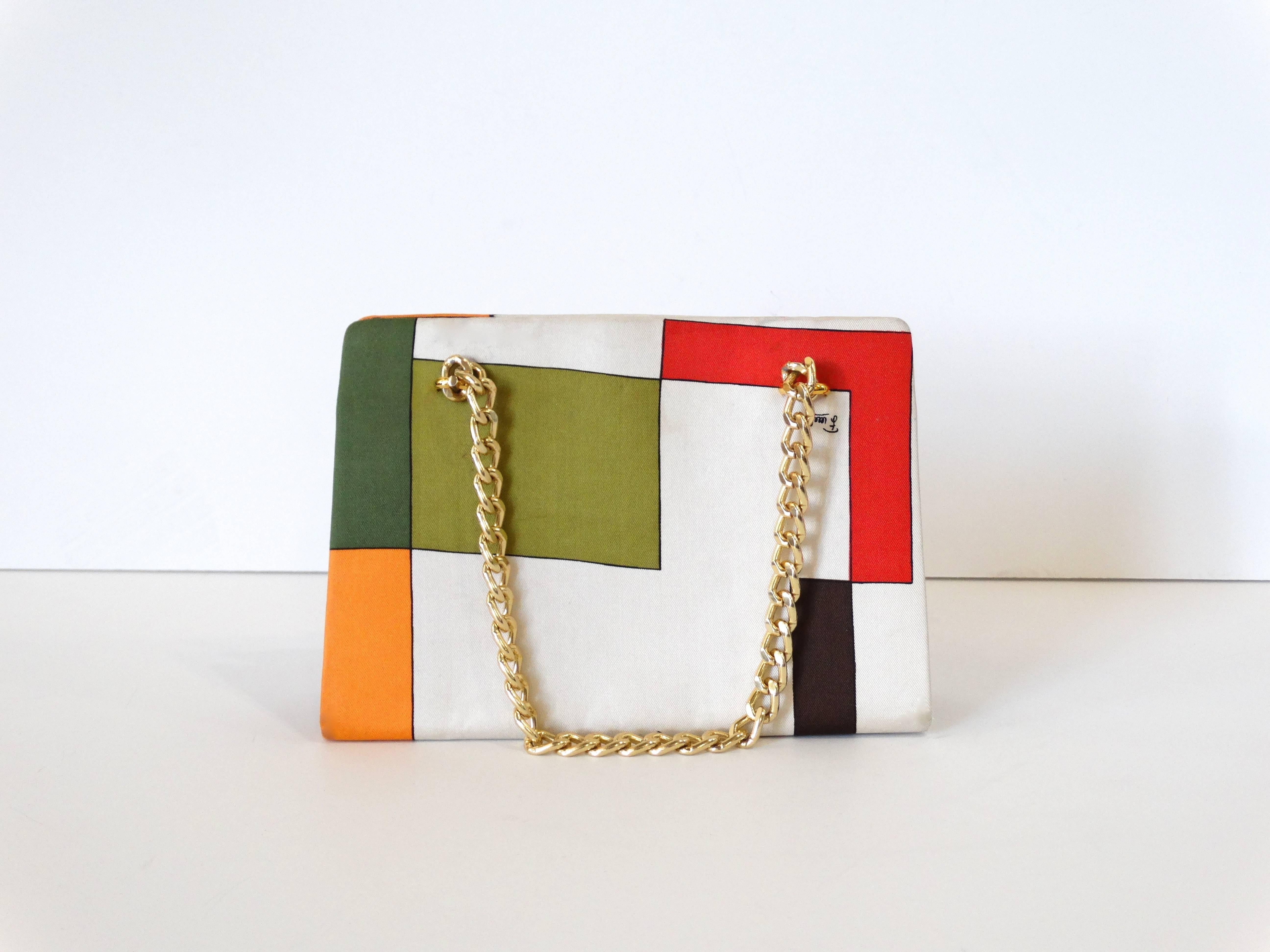Art meets fashion in this incredible 1960s Pucci Bag! Soft silk fabric printed with geometric pattern in shades of green, red and orange. Gold chain and hardware-  kiss lock closure with fully lined interior. 

Measurements:

Height: 5.5