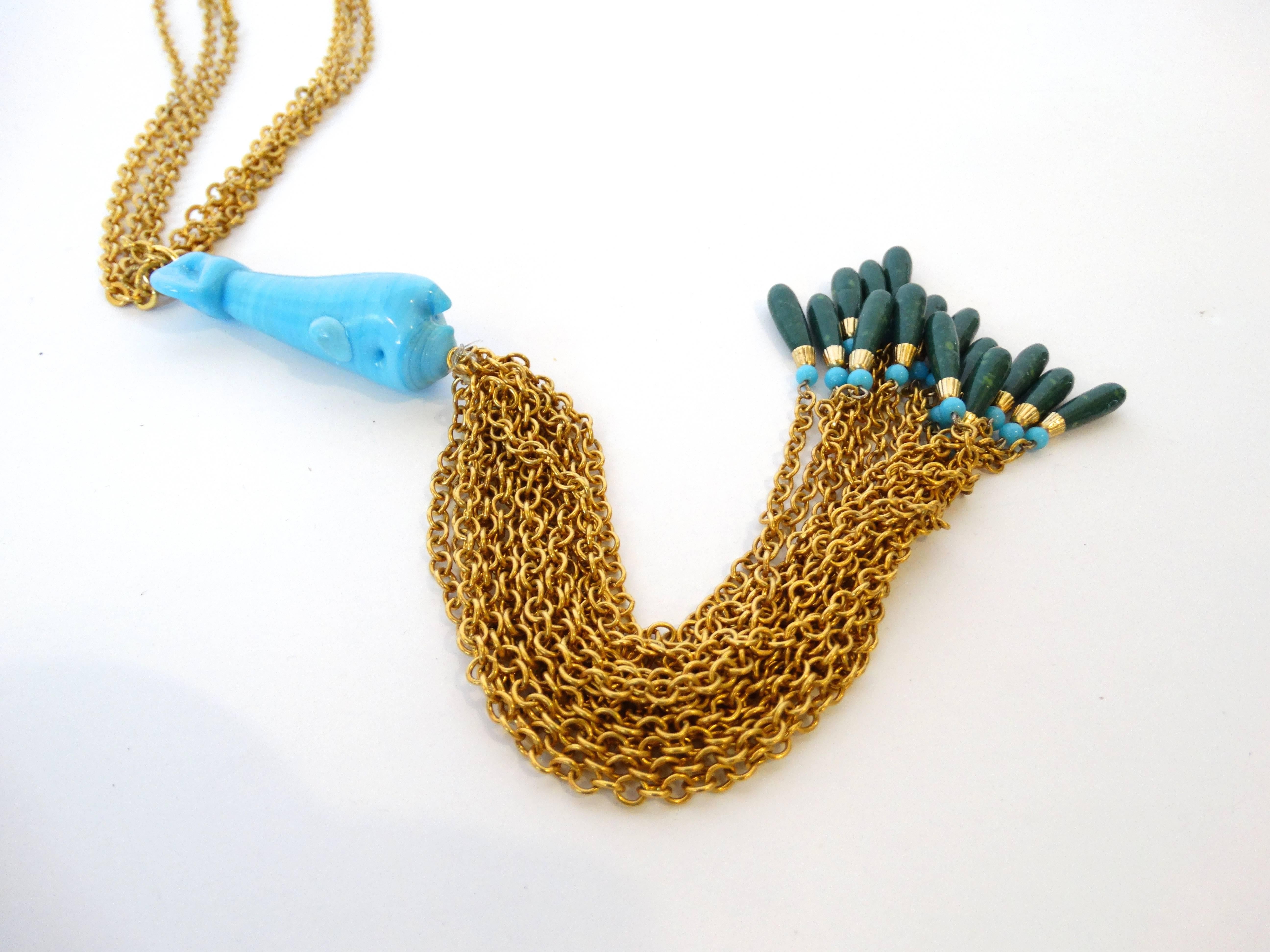A beautifully sculptured necklace created by William de Lillo in the 70's! This necklace features a turquoise glass whale sculpture in center of the necklace with 15 gold plated chains hanging from the front of the whale that drop down 8