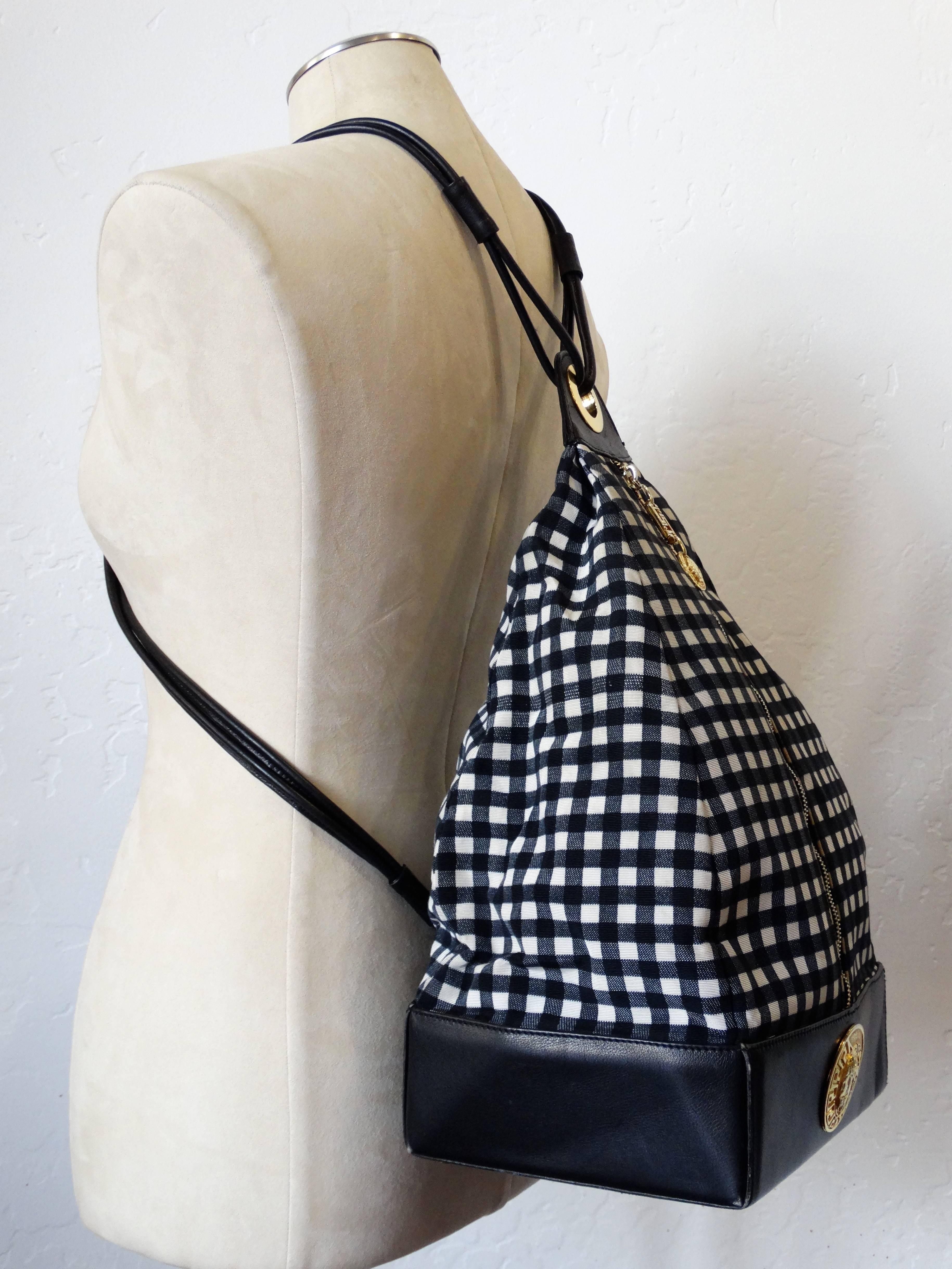 A fabulous 1990's Versace couture black and white gingham backpack with large Versace medusa medallion. Black leather straps with zip up closure classic Versace pull with Greek key symbol and Medusa face. Bottom is wrapped in black leather and gold