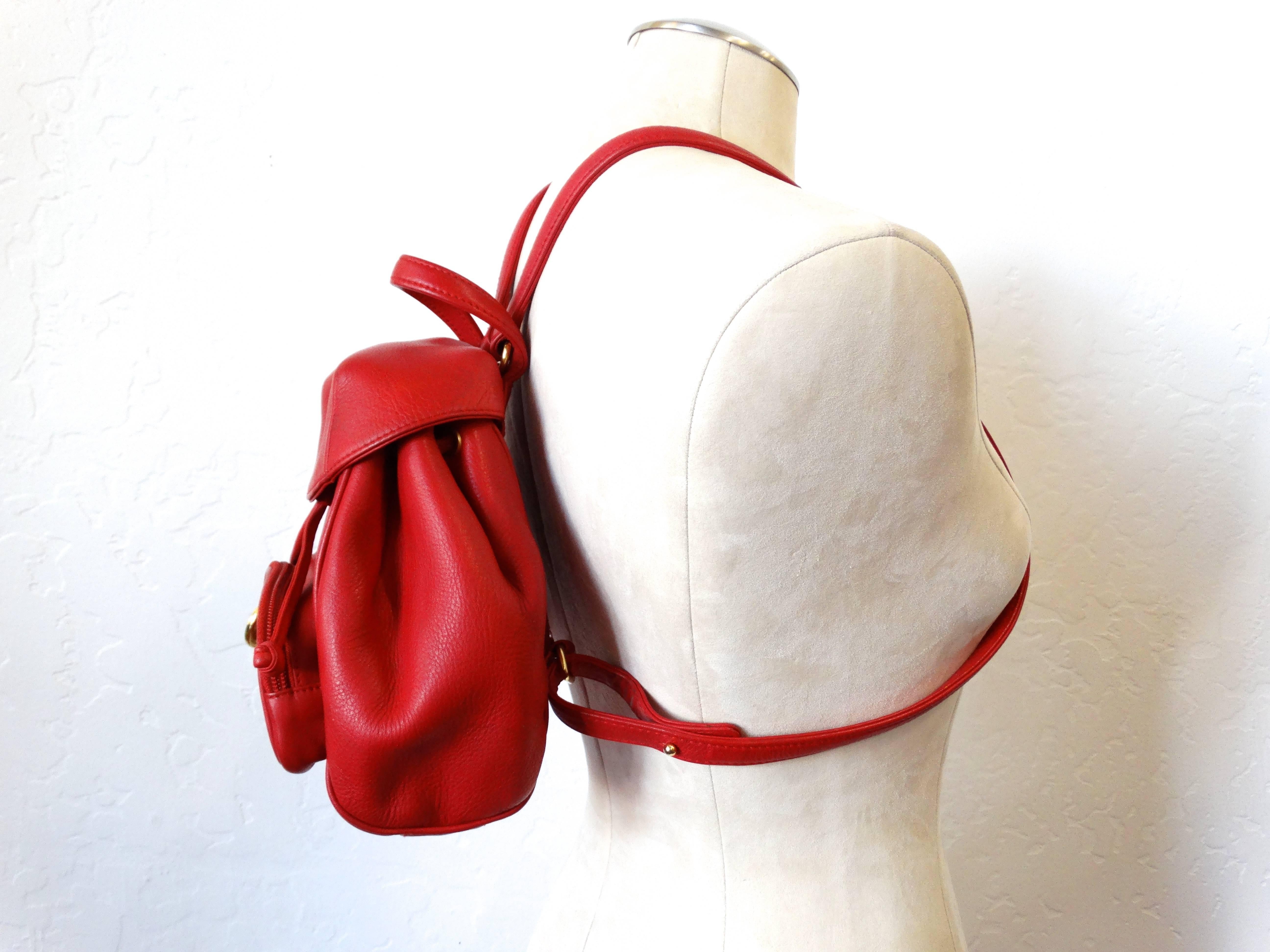 mini CHRISTIAN DIOR Lipstick Red Backpack. Gold tone hardware, small top handle, two adjustable back straps, leather drawstring pull at top with magnetic popper fastening, inside zip pocket, small front pocket with iconic gold CD logo with zipper
