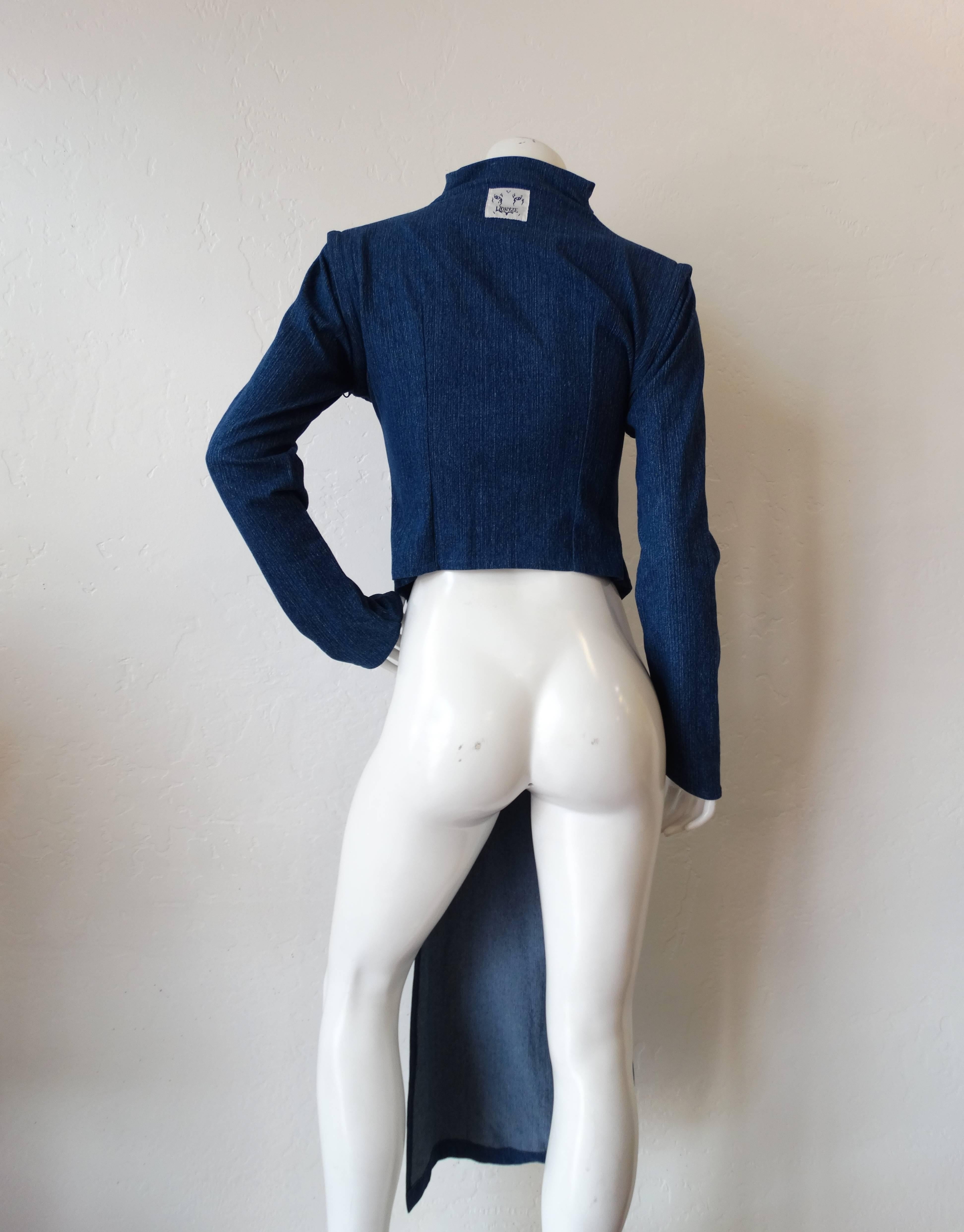 This piece is definitely one of a kind! Interesting Japanese inspired silhouette-
long panel down the front, high neckline and long sleeves. Made of a stretch denim material in a true blue. Front panel and sleeves zip off and detach, allowing for a