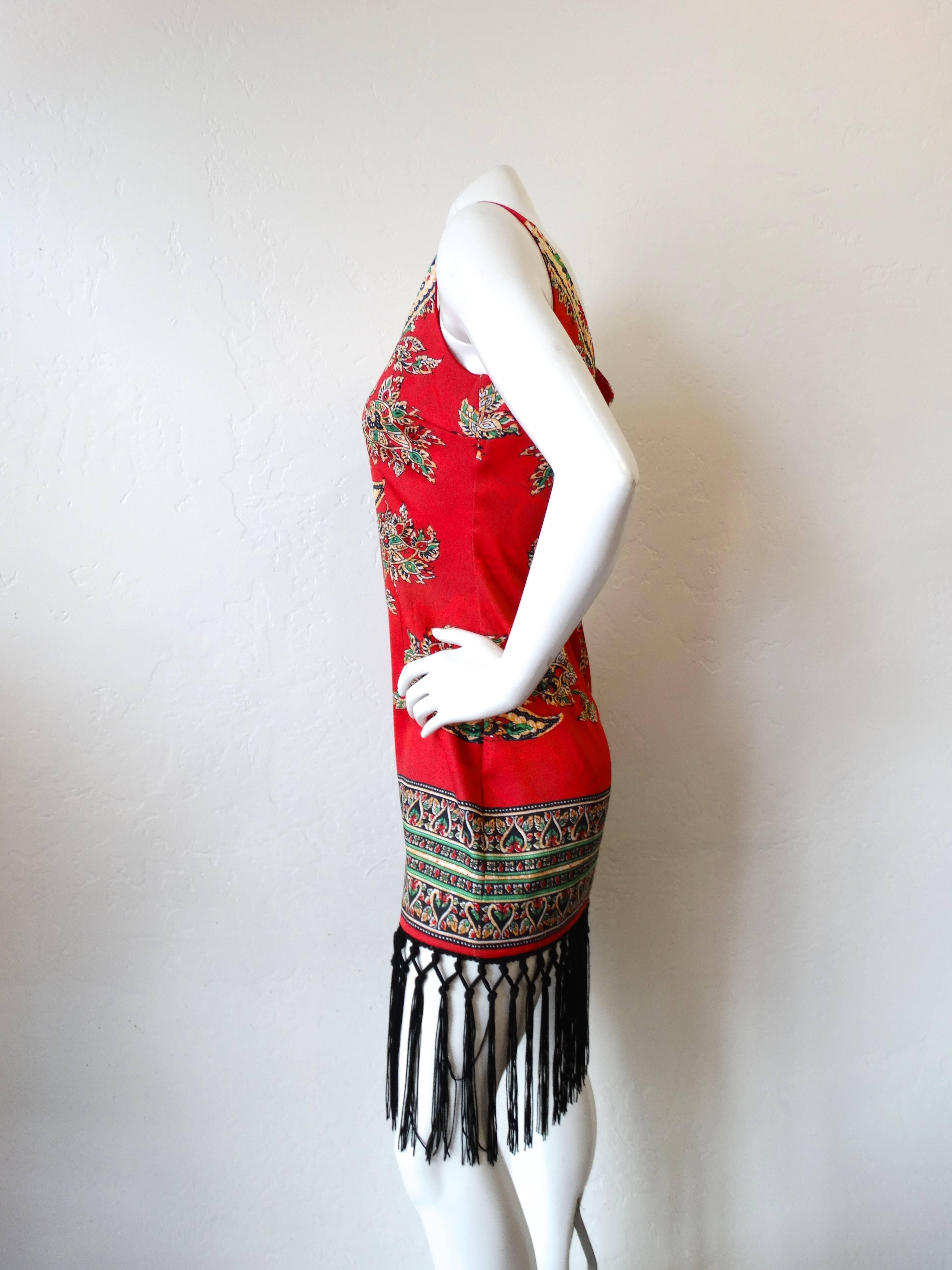 Incredible 1990s Dashiki printed dress with long black fringe trim! Sexy fitted silhouette with plunging V neck and back. Dashiki inspired print in a bold bright red! Hidden zipper up the back. Marked a size 8, best fits a Medium. 

Measurements: