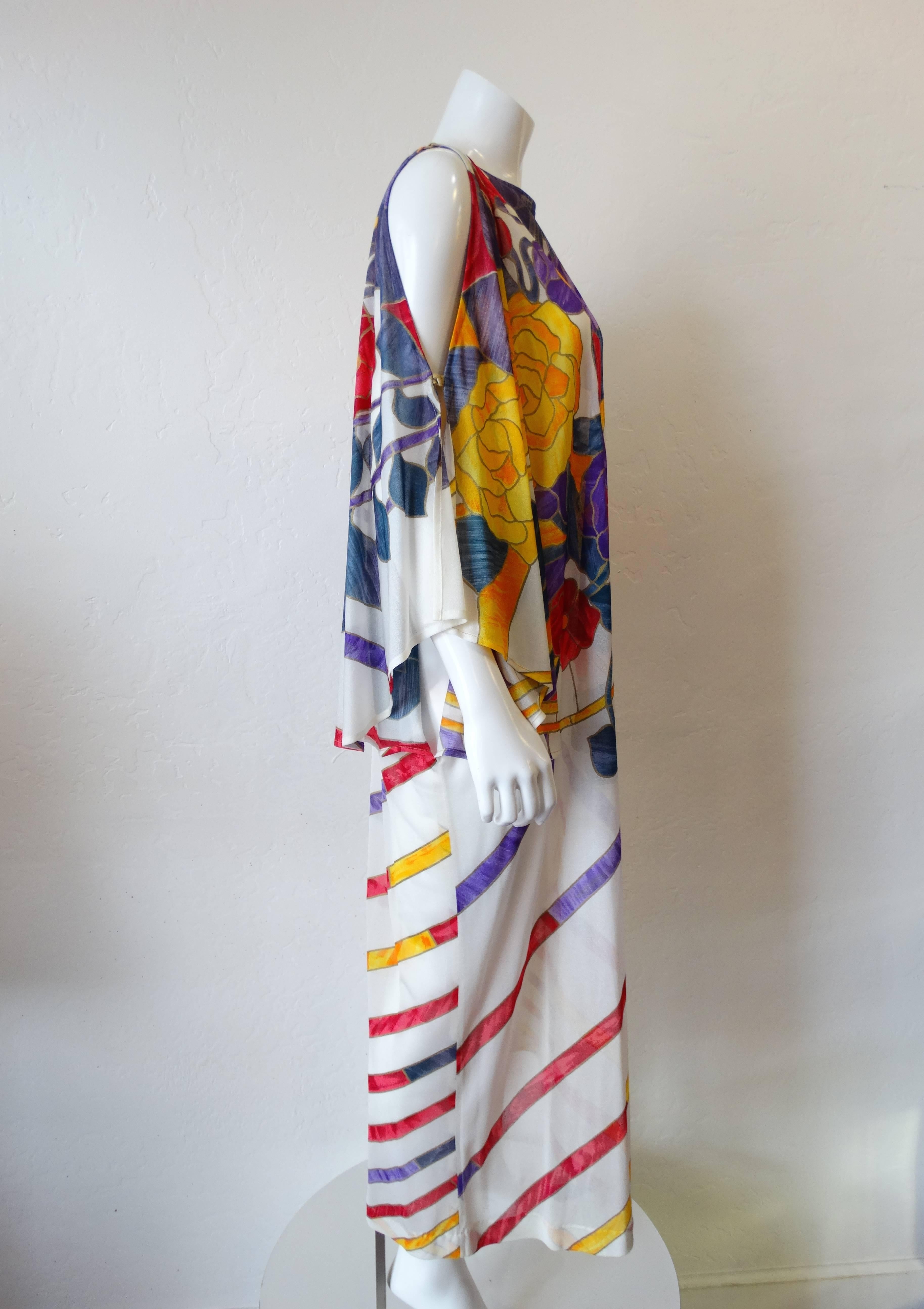Look like a Goddess in this rare piece from coveted 1970s designer Gottex. Dreamy maxi fit with sexy slits on the fluttery sleeves. Bold stained glass inspired floral print with stripes down the skirt on semi sheer fabric. Marked a size Medium- can