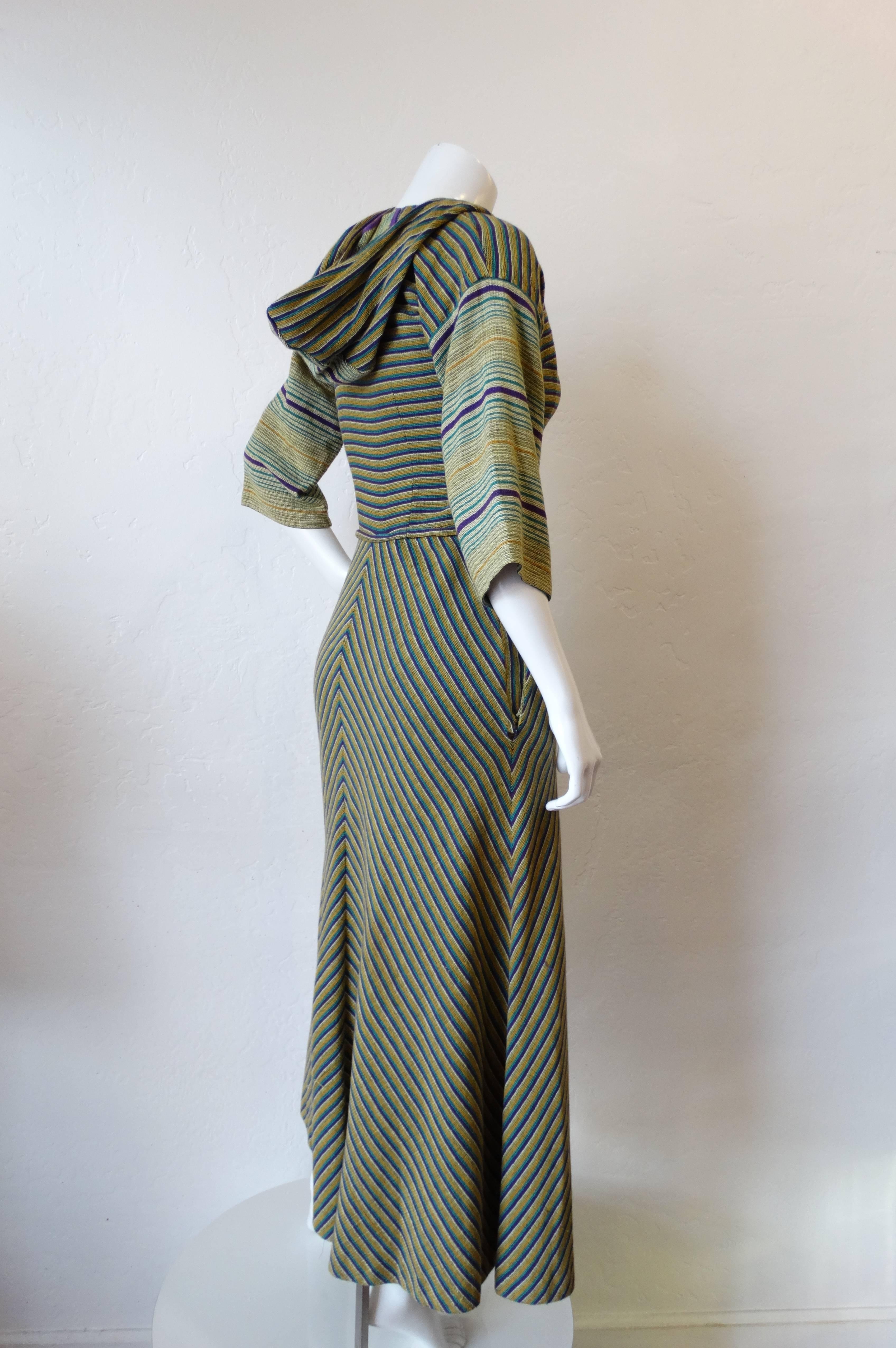 1970s hooded dress from the coveted Israeli designer Rikma! Sexy zip up closure up the front. Thick woven cotton in a purple, teal, and yellow striped print. Maxi length silhouette with unique hood detail and pockets at the hips! Best fits a size