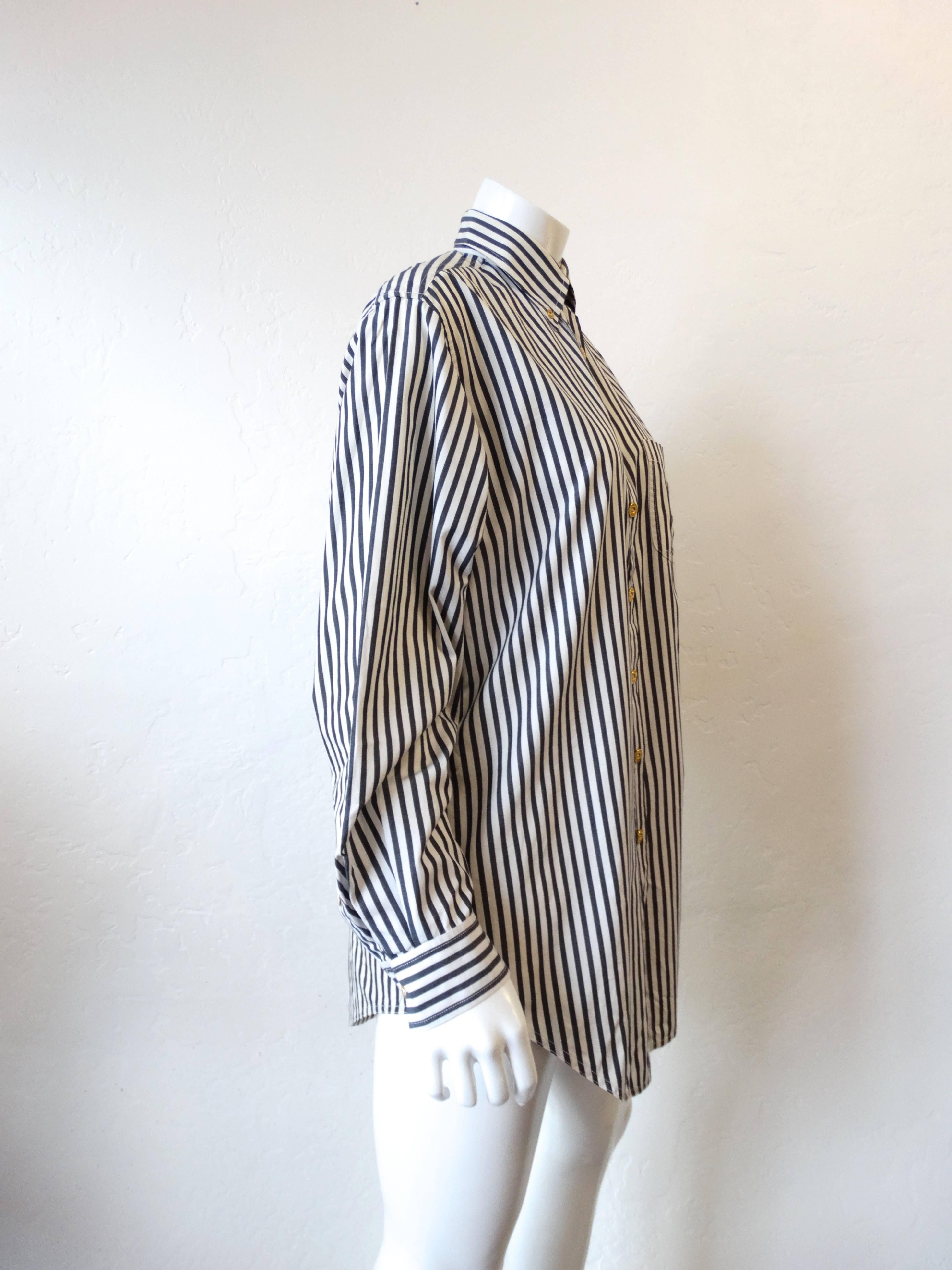 Rock the resurgence of the logo trend in this 1990s Chanel Button Up! Grey and white striped print on cotton fabric. Embroidered CC logo at the breast pocket in deep grey. Gold Chanel embossed buttons up the front and on the wrists. Wear as a dress