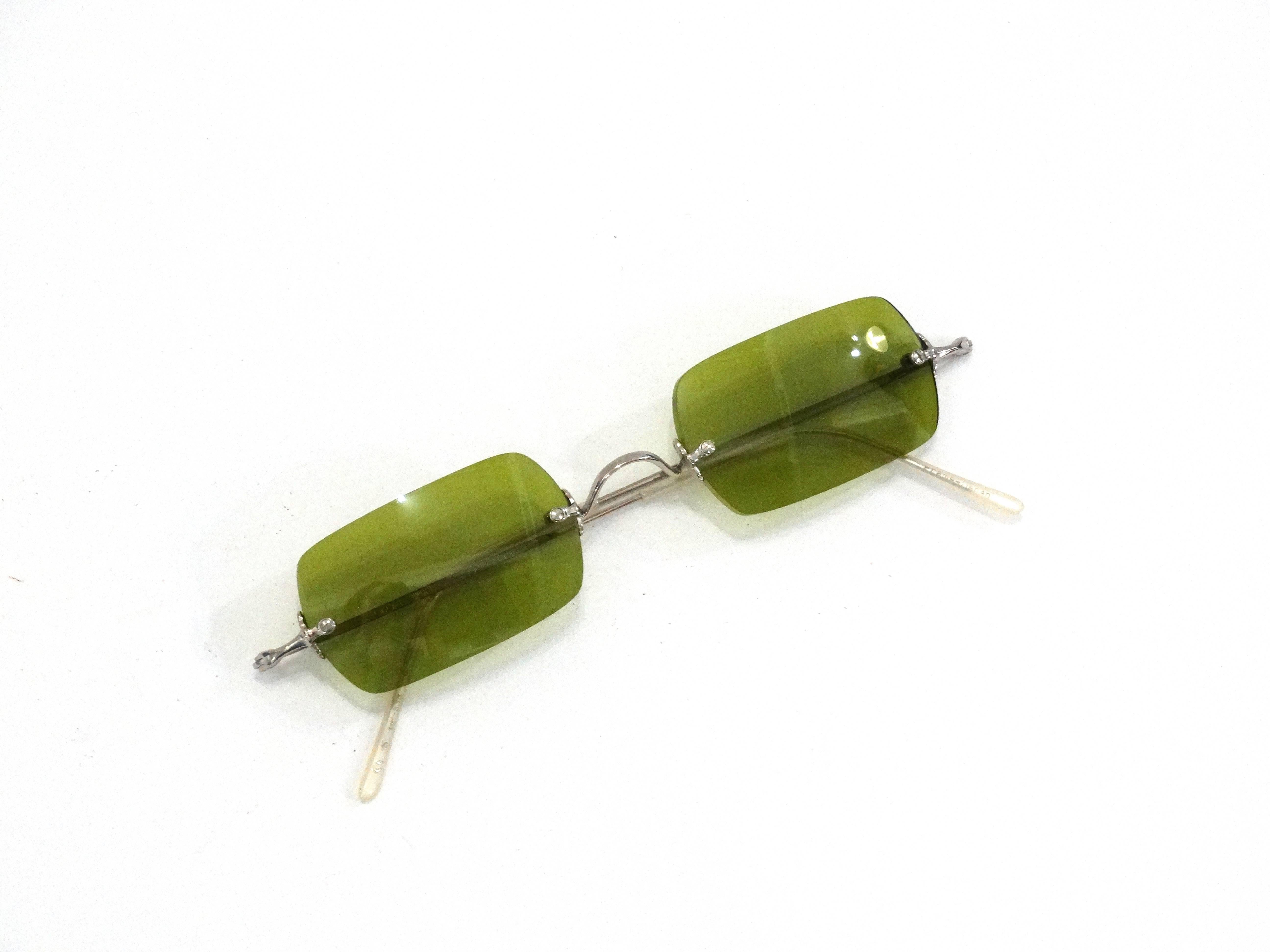 Colored sunglasses are SO en vogue- rock this pair of Oliver Peoples' sunglasses in a rare olive green color! Silver wire hardware. Comes with original leather case. 

Lens Height: About 1 inches
Lens Width: About 2 inches 