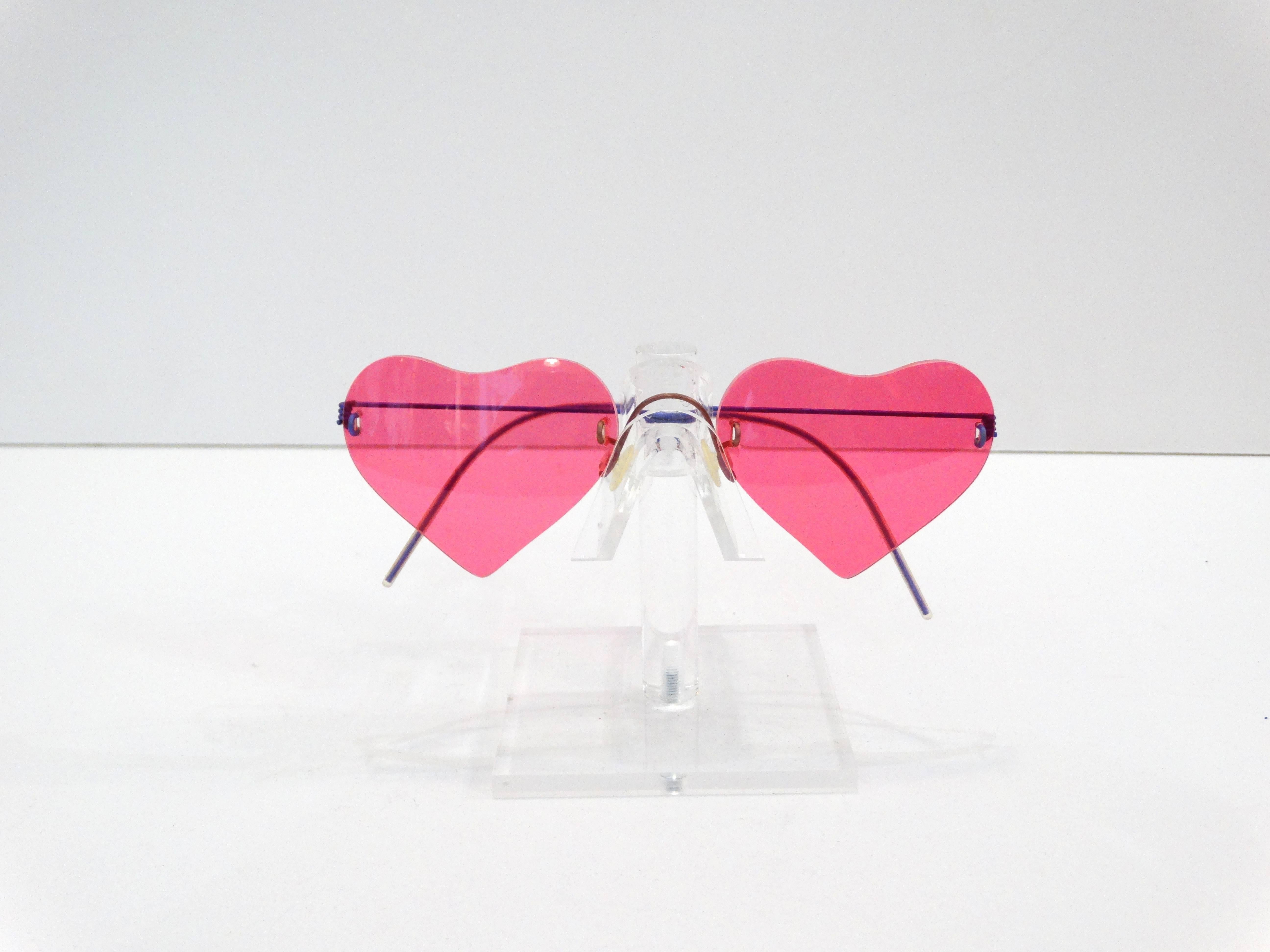 Serve the iconic Lolita look in these vintage Lindberg heart shaped frames! Pink laser cut glass with purple wire frames! Comes with original case and yellow cleaning cloth. 

Lens Height: 1.75
