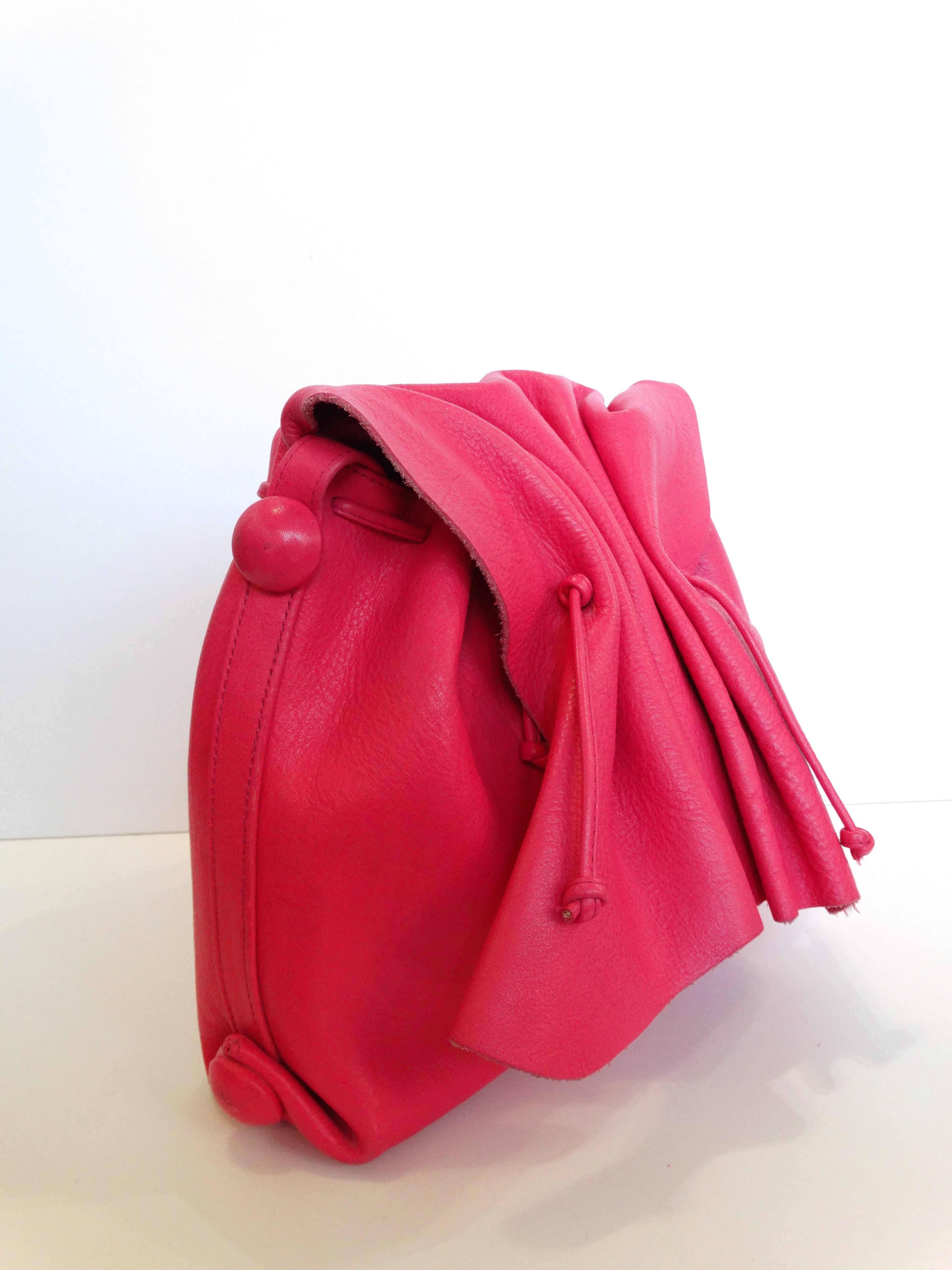 1980s Carlos Falchi cinched flap shoulder bag! 100% leather in a unique bubblegum pink color. Flap closes with magnet. Features a drawstring closure on the interior beneath the flap. Zipper pouch in the interior. Shoulder strap drops 18 inches 