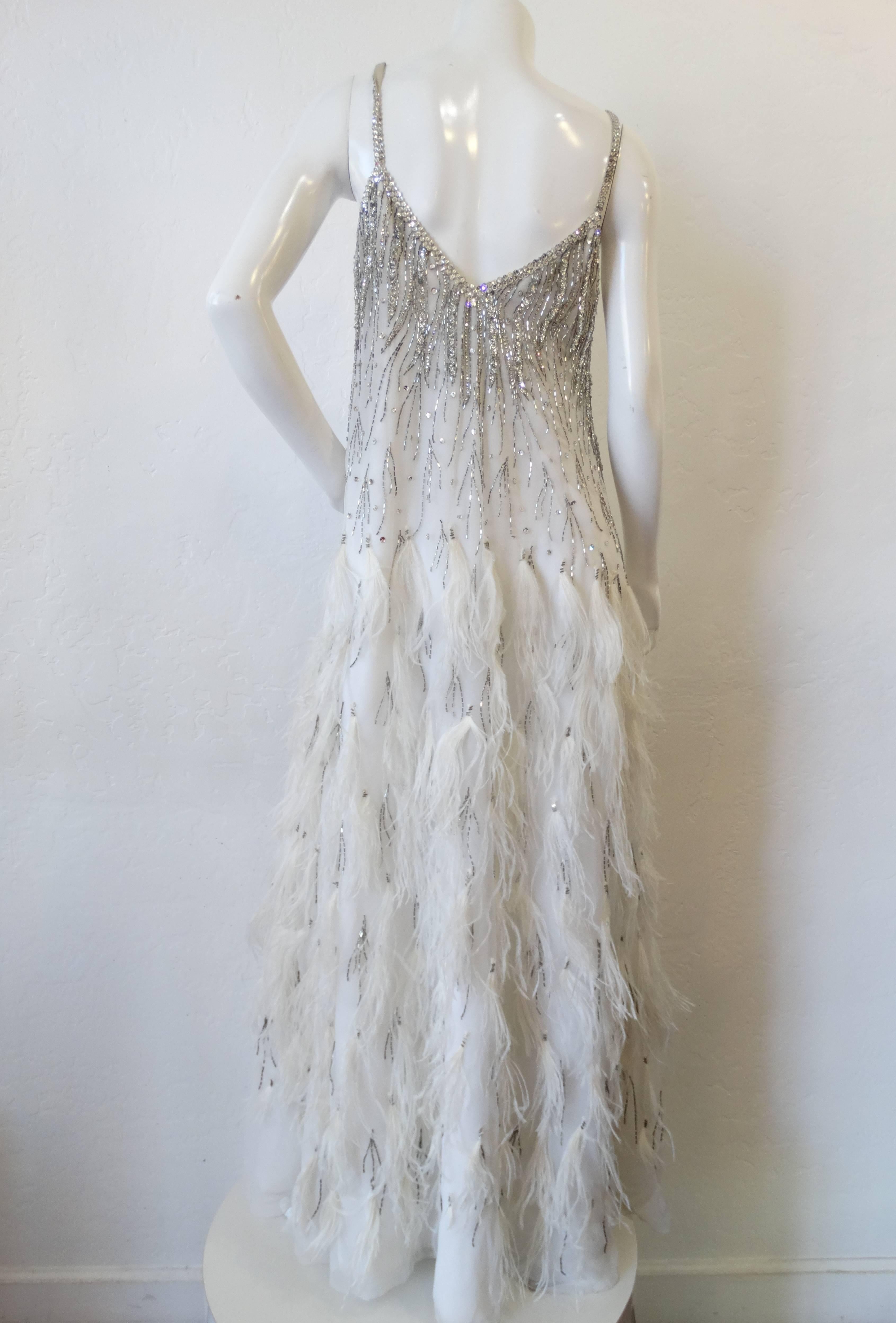 Channel the glamour of the 20s with this incredible beaded 1980s Rubin Panis Gown! Layered white chiffon cascades down to the floor- accented with a generous amount of ostrich feathers sewn in tufts. Silver beads and rhinestones stud the bodice and