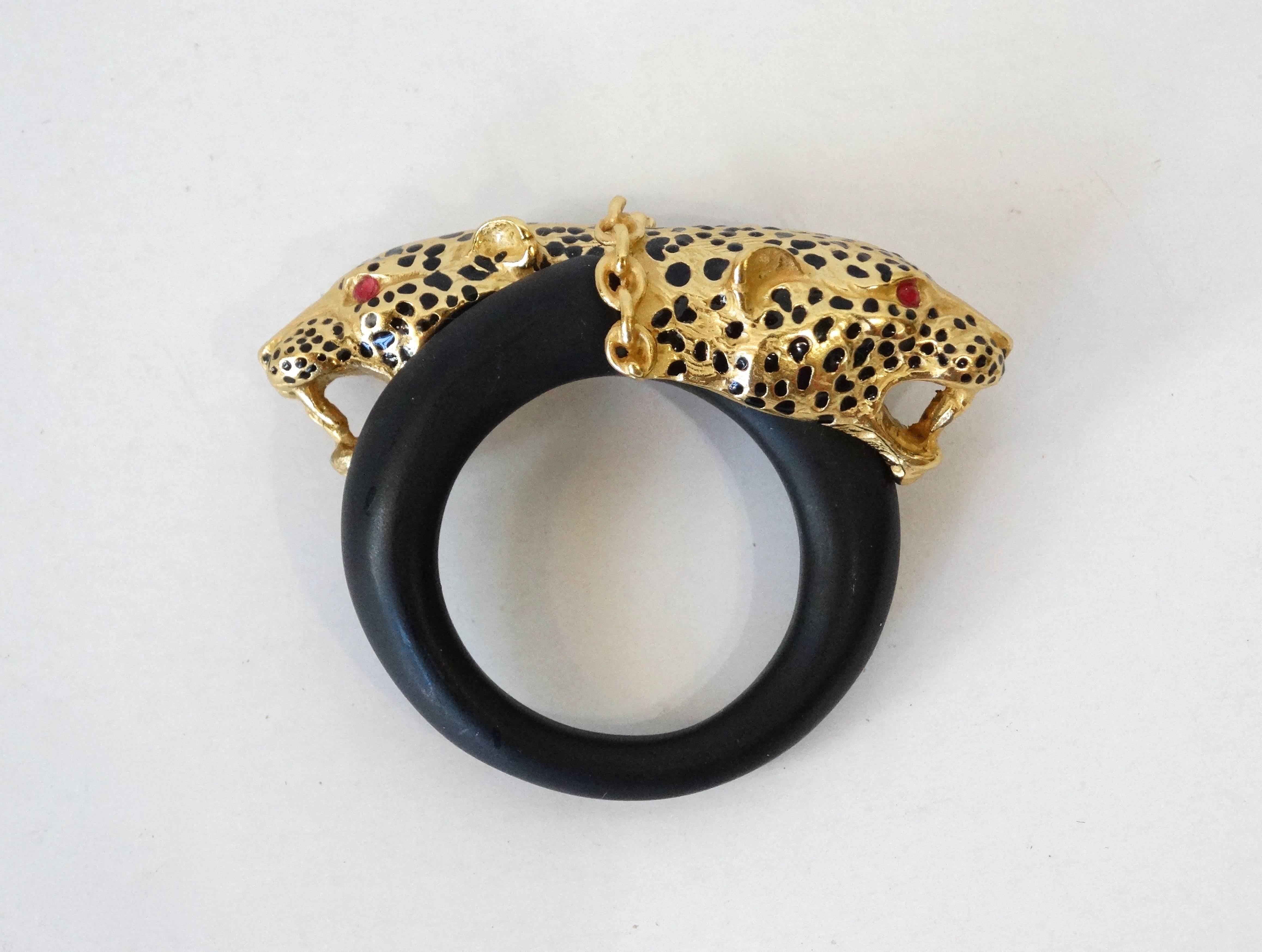 1980's Gorgeous Franklin Mint,Panther Brooch plated in 22kt gold with ruby rhinestone eyes. The panther heads measure 2 inch across the top and about 3/4 inch wide. The brooch is about 1 inch wide and thick. Panther head has black enamel accents.