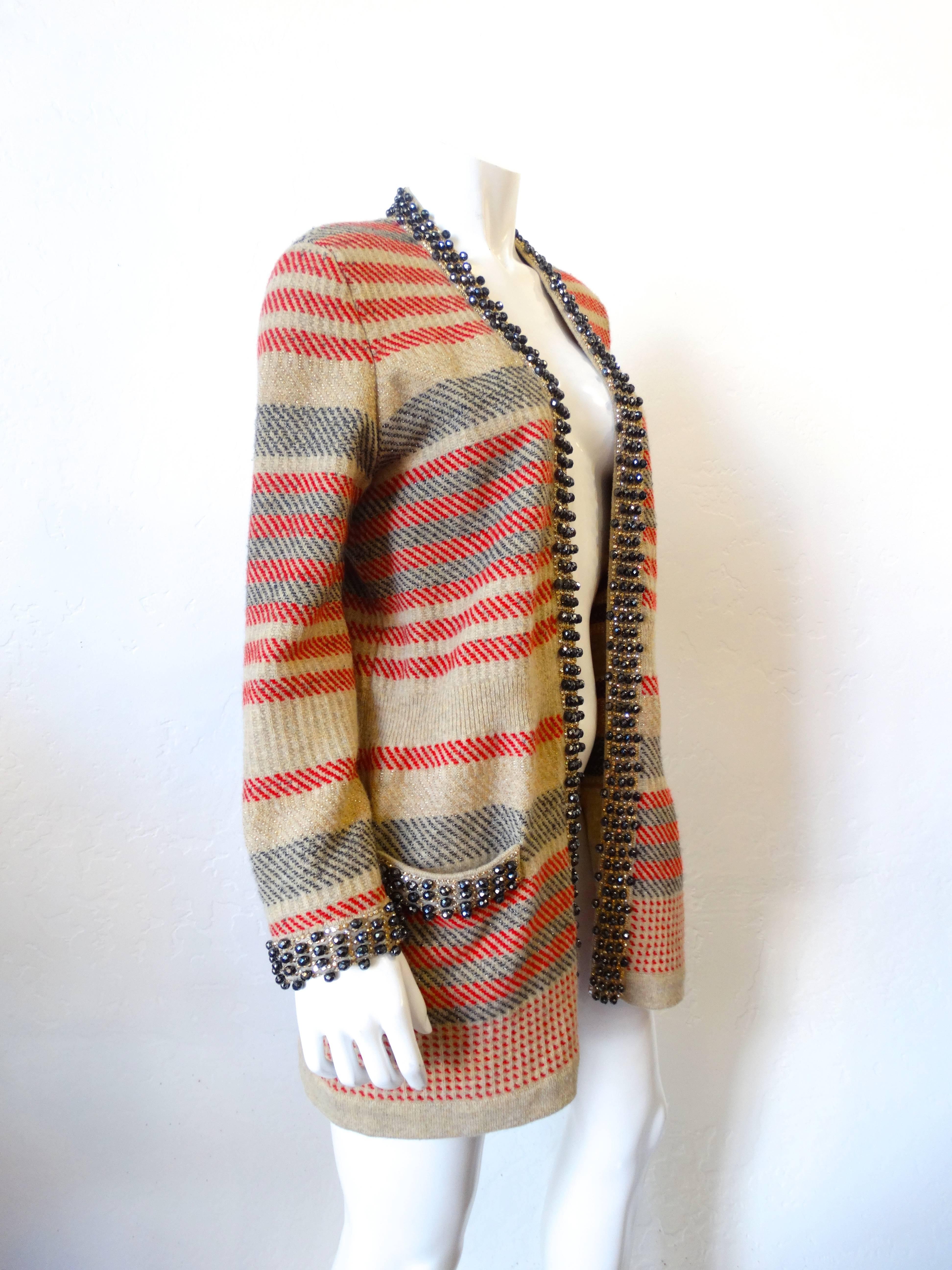 The perfect fall knit cardigan from 2007 created by Chanel!  Multi-color stripe cardigan. Red, gold and navy striped cardigan featuring gunmetal glass beading detail at collar, pockets, and sleeve cuffs. Made in Italy. 

