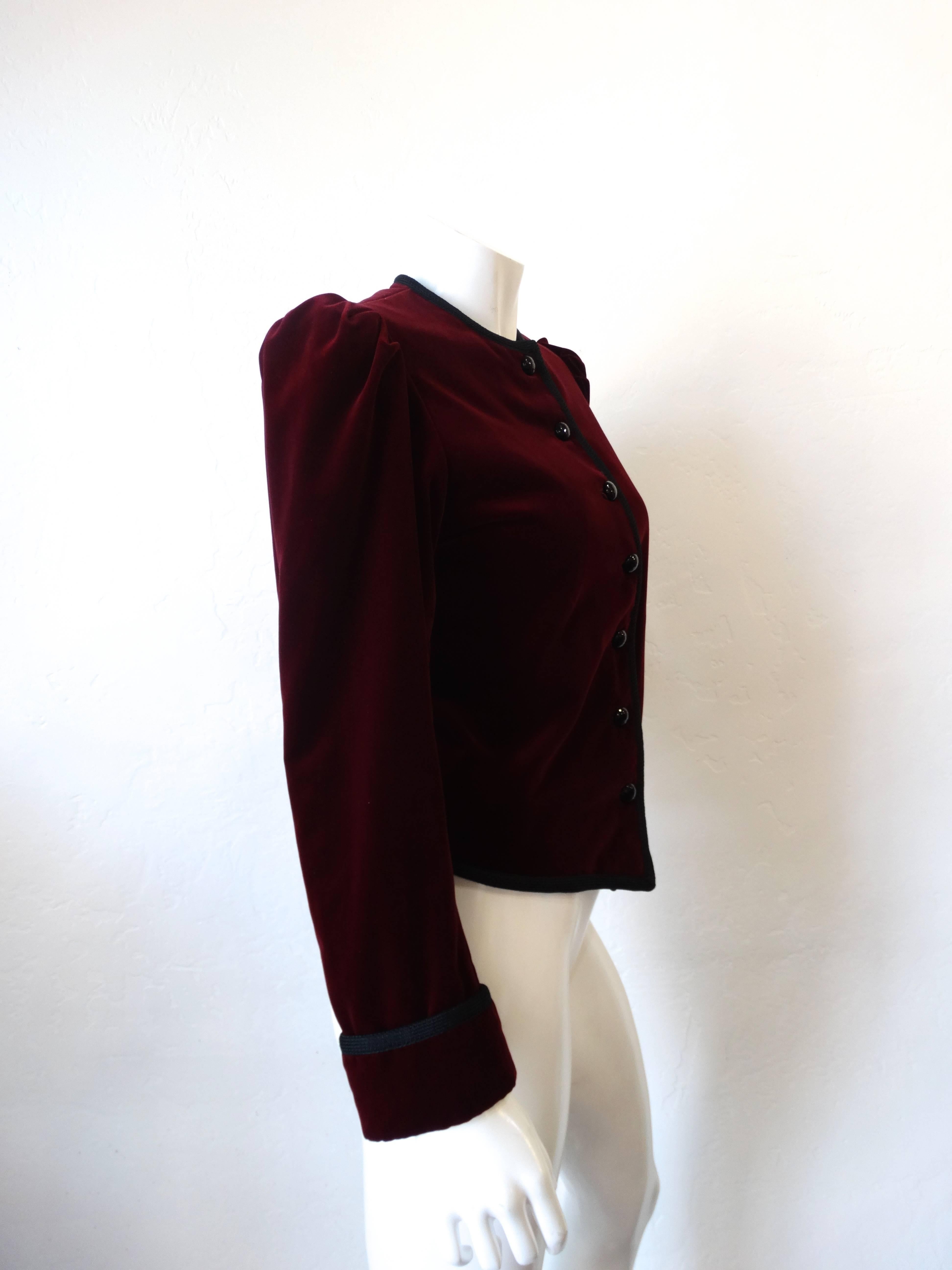 1970s Velvet coat from Saint Laurent Rive Gauche! Fitted through the bodice with dramatic puff sleeves and tapered arms. Made of thick burgundy velvet with black knit trim. Black buttons up the front of the jacket. Fully lined satin interior. Marked