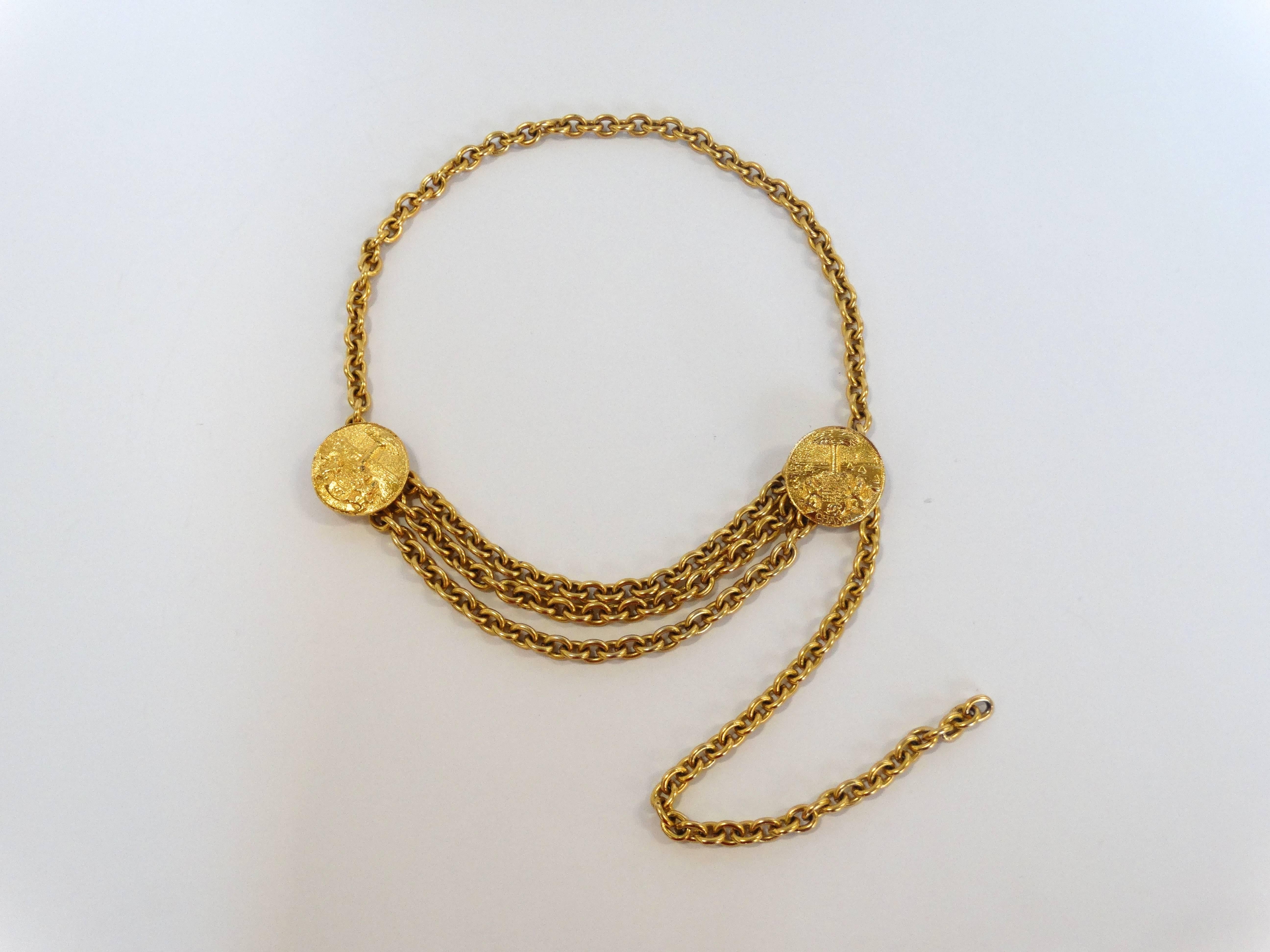 1980s Classic Chanel belt or necklace in a brilliant gold color! Heavy chain construction with two medallions at either side of the hip. Three chains hang down from the medallions to add movement and drama. Simple hook closure allows for this piece