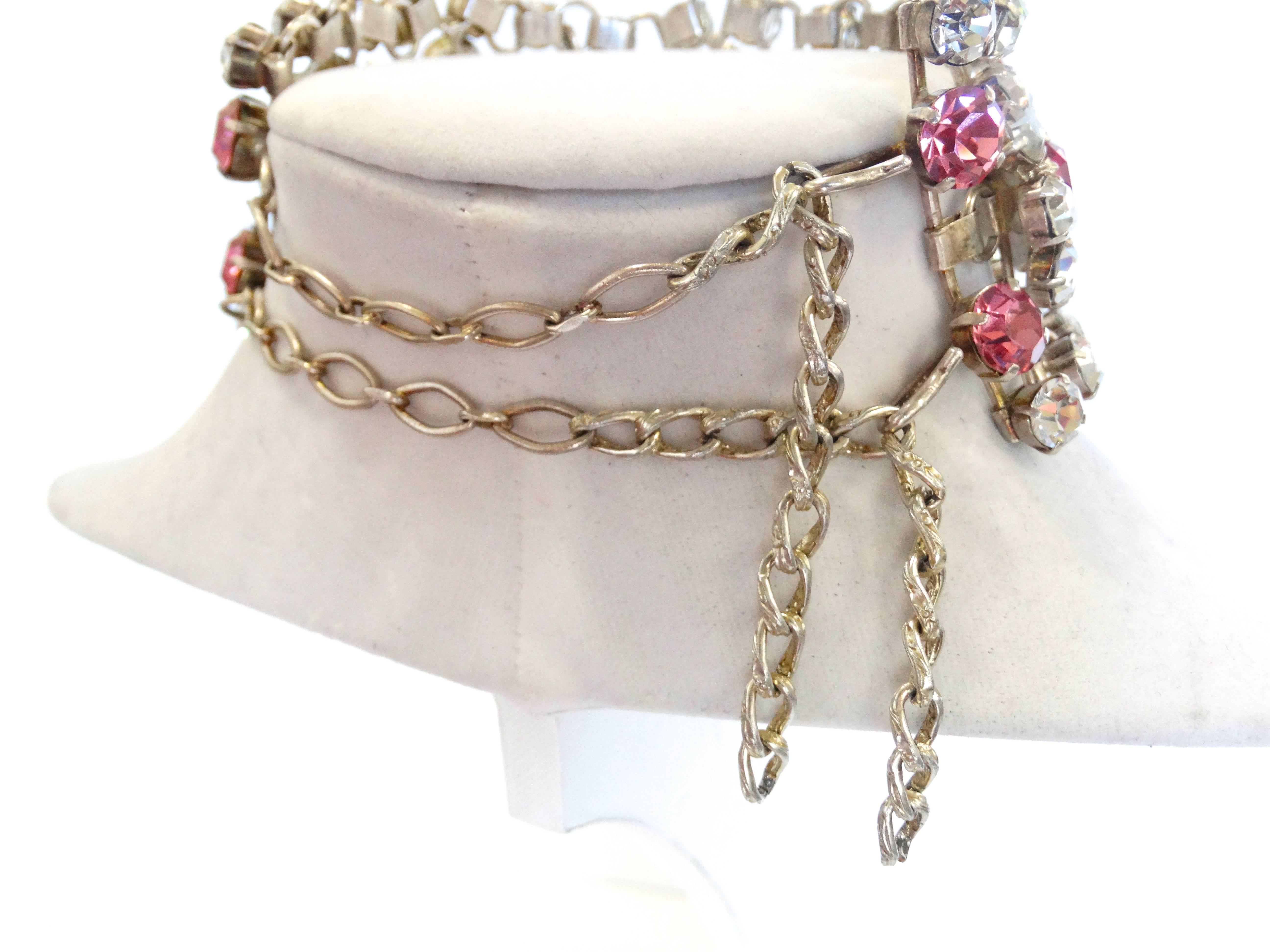 Show stopping Pink and Clear rhinestone choker necklace from the 1960s! Clear and bright pink rhinestone gems on silver hardware, floral pattern in center. Two hook closures at the back of the neck. Simply stunning on!!!

2.4 inches Width
15 inches
