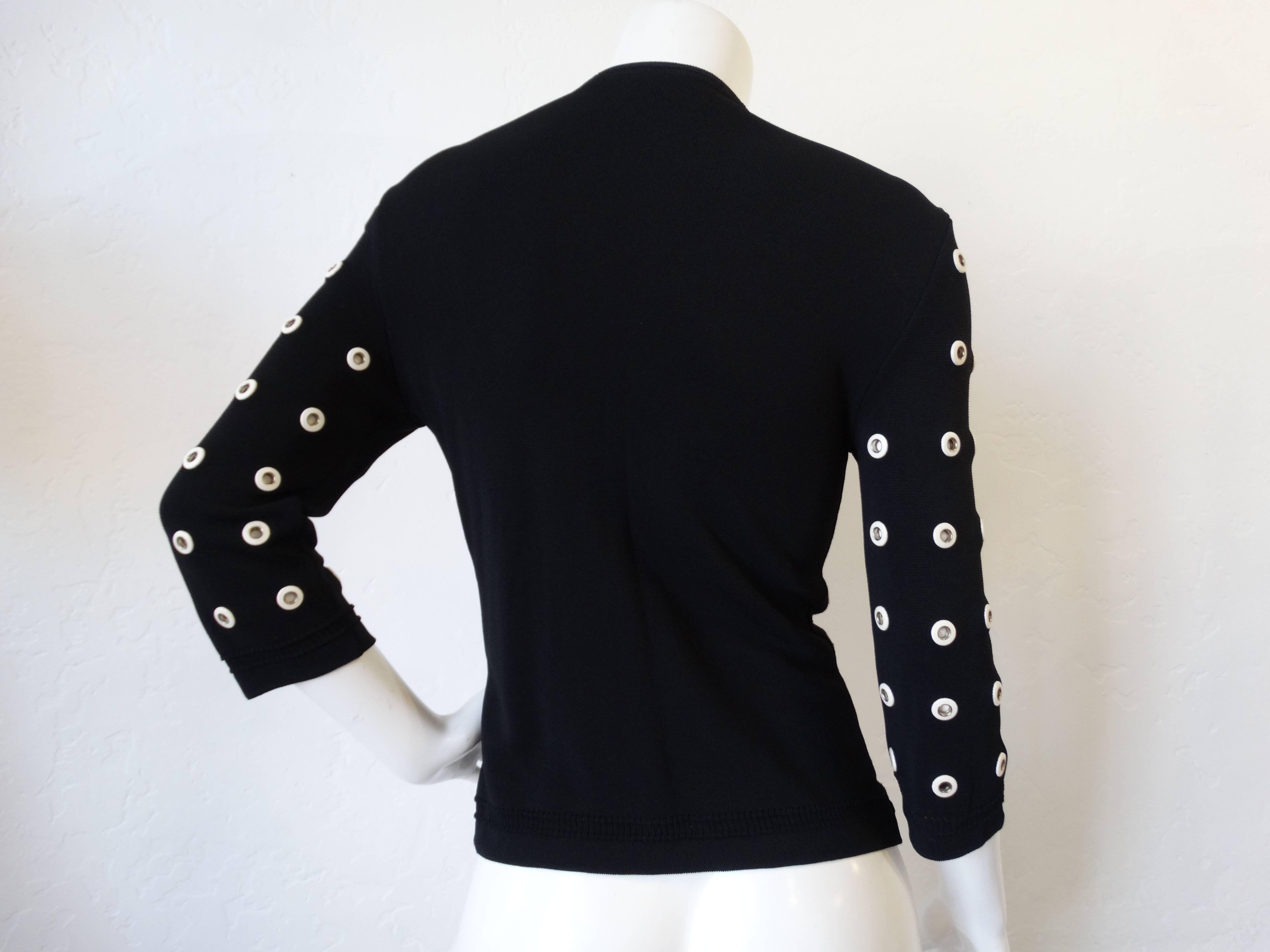 Edgy leather eyelet cardigan sweater from Gianfranco Ferre! Black knit fabric accented with leather white eyelets all over! Snaps up the front with matching eyelet buttons. Marked a size 44, best fits a small. 

Bust: 34”
Length: 25”
Sleeve: 17.5”