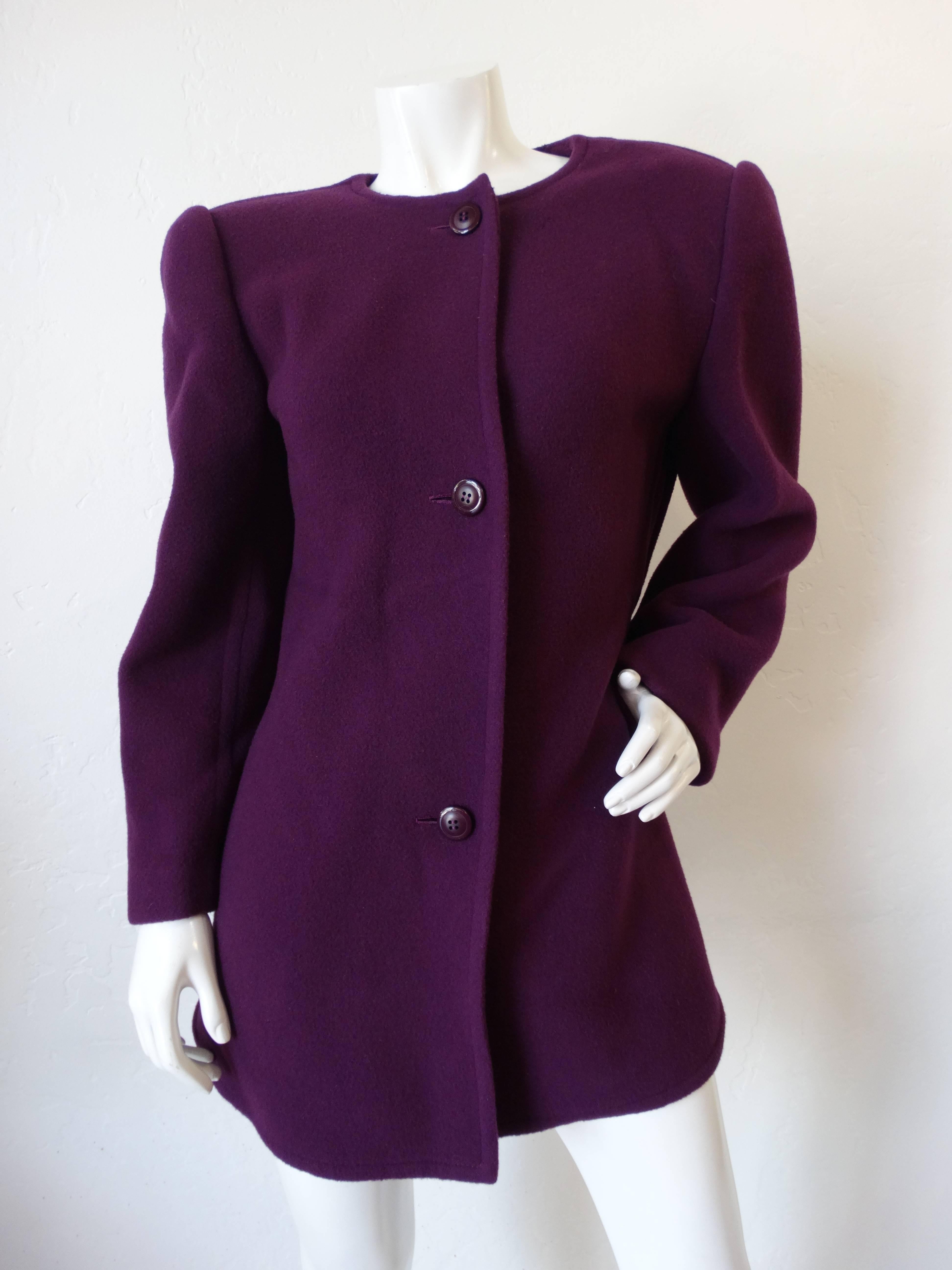 Channel the power dressing spirit of the 1980s with this strong shouldered jacket from prolific designer, James Galanos! Made of a soft wool blend in a brilliant eggplant purple color. Buttons up the front with matching buttons. Back of the jacket